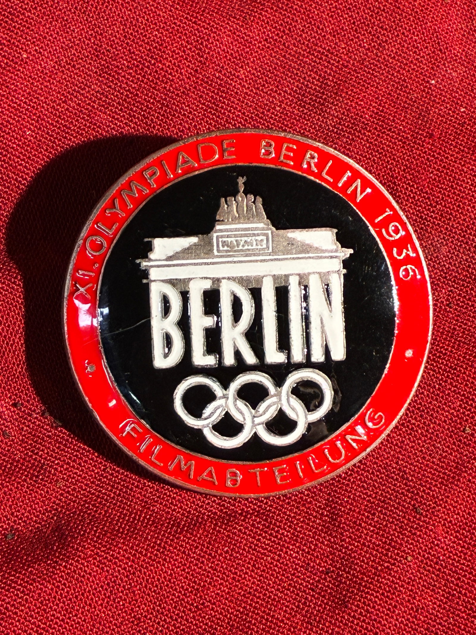 WW2 German 1936 Berlin Olympic Film Department Badge: This circular enamel badge was issued to personnel of the Filmabteilung (Film Department) during the 1936 Summer Olympics in Berlin, an event extensively used by the Nazi regime for international prop