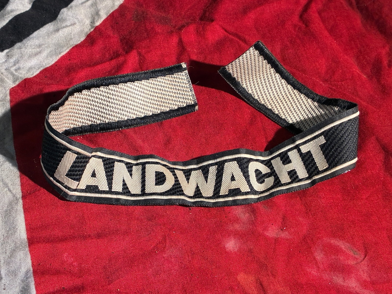 WW2 German Landwacht Cuff Title (German Auxiliary Militia), c. 1944–1945: This cuff title belonged to a member of the Landwacht, a late-war German auxiliary militia formed during the final phase of the Second World War. The black woven band, displaying the word LANDWACHT in