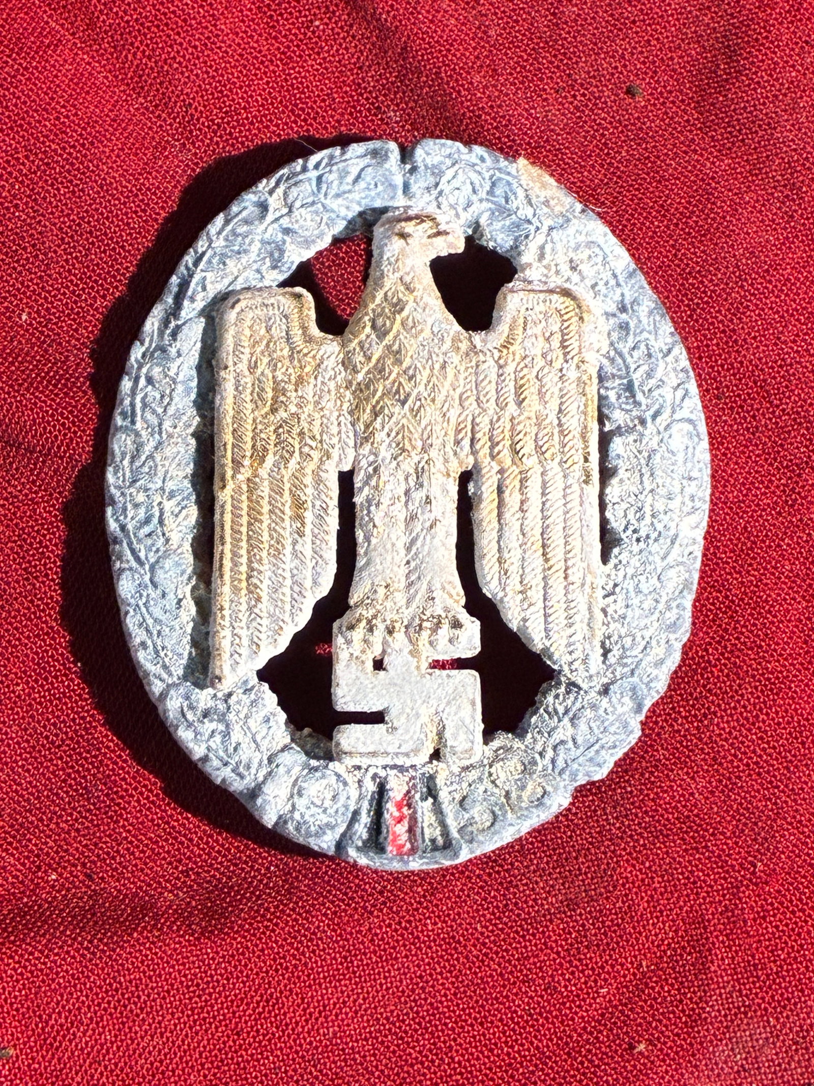WW2 German Third Reich Party Eagle Badge: This object is a heavily corroded political eagle badge used in Nazi Germany during the 1930s–1940s. The piece features the stylized eagle grasping a swastika—an emblem adopted as the primary insi