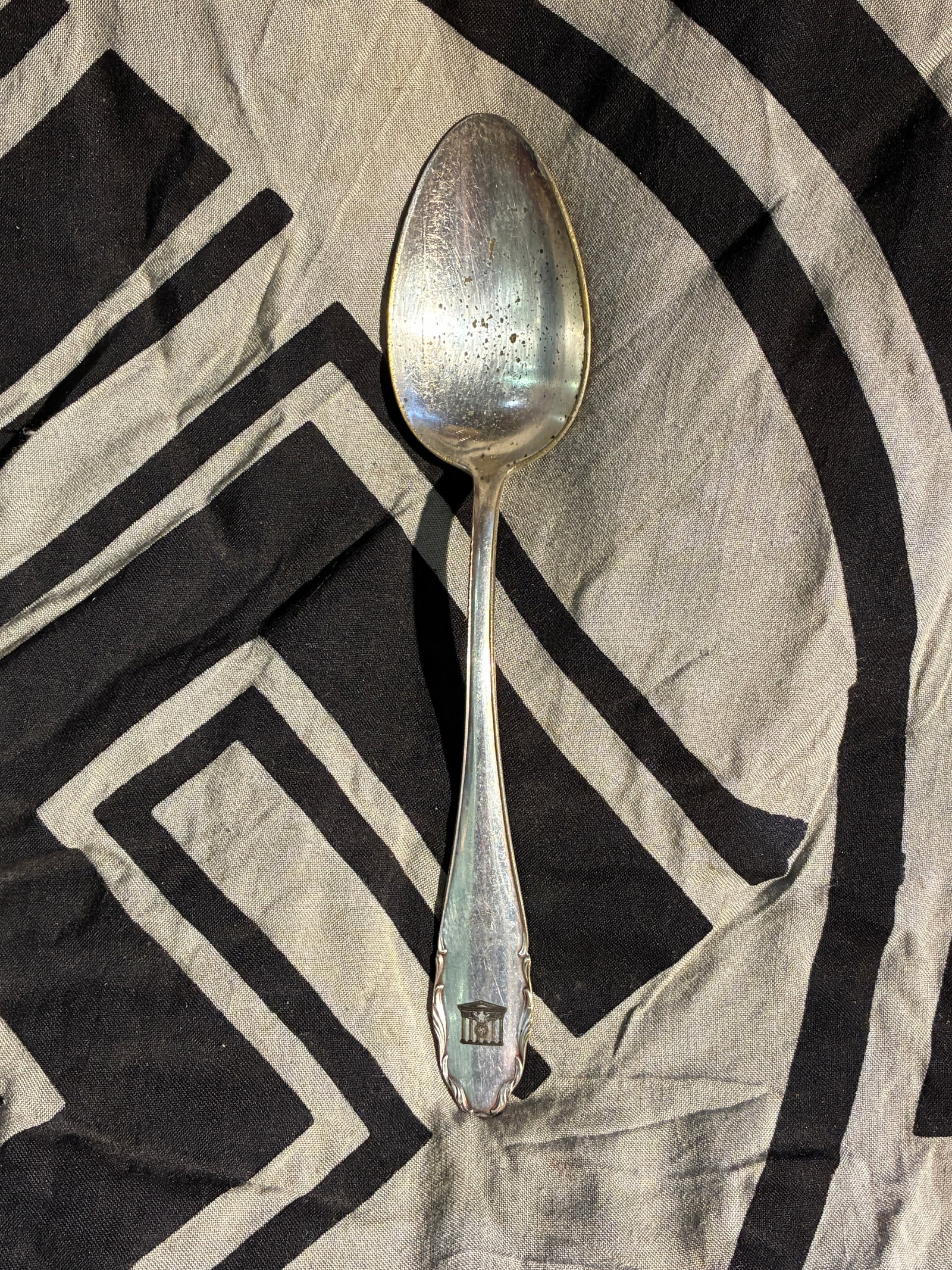 WW2 German Government Eagle–Marked Table Spoon (c. 1930s–1940s): This silver-plated table spoon bears a stylized German national eagle perched atop a wreath and flanked by architectural columns, an emblem used by state institutions in Germany during the 1930s and e