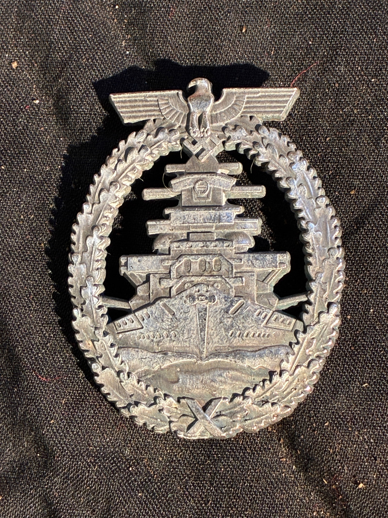 WW2 German Kriegsmarine Battleship War Badge (Bismarck Class) — “Schwerin Berlin?? Variant: This metal badge is a Kriegsmarine Battleship War Badge (Schlachtschiffskriegsabzeichen), originally instituted in 1939 for crewmen who served aboard German battleships and cruisers. The design featur