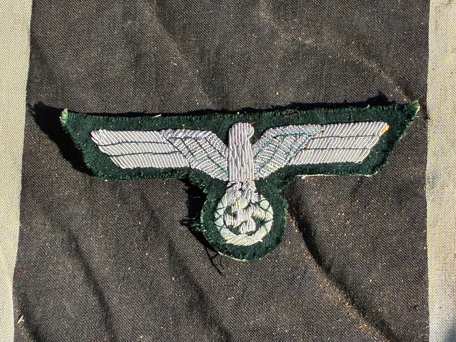 WW2 German Police Uniform Eagle (Schutzpolizei) – Hand-Embroidered Insignia, 1936–1945: This hand-embroidered cloth eagle insignia was worn on the upper left sleeve of uniforms issued to members of the Schutzpolizei, the uniformed branch of the German Order Police during the Nazi period.