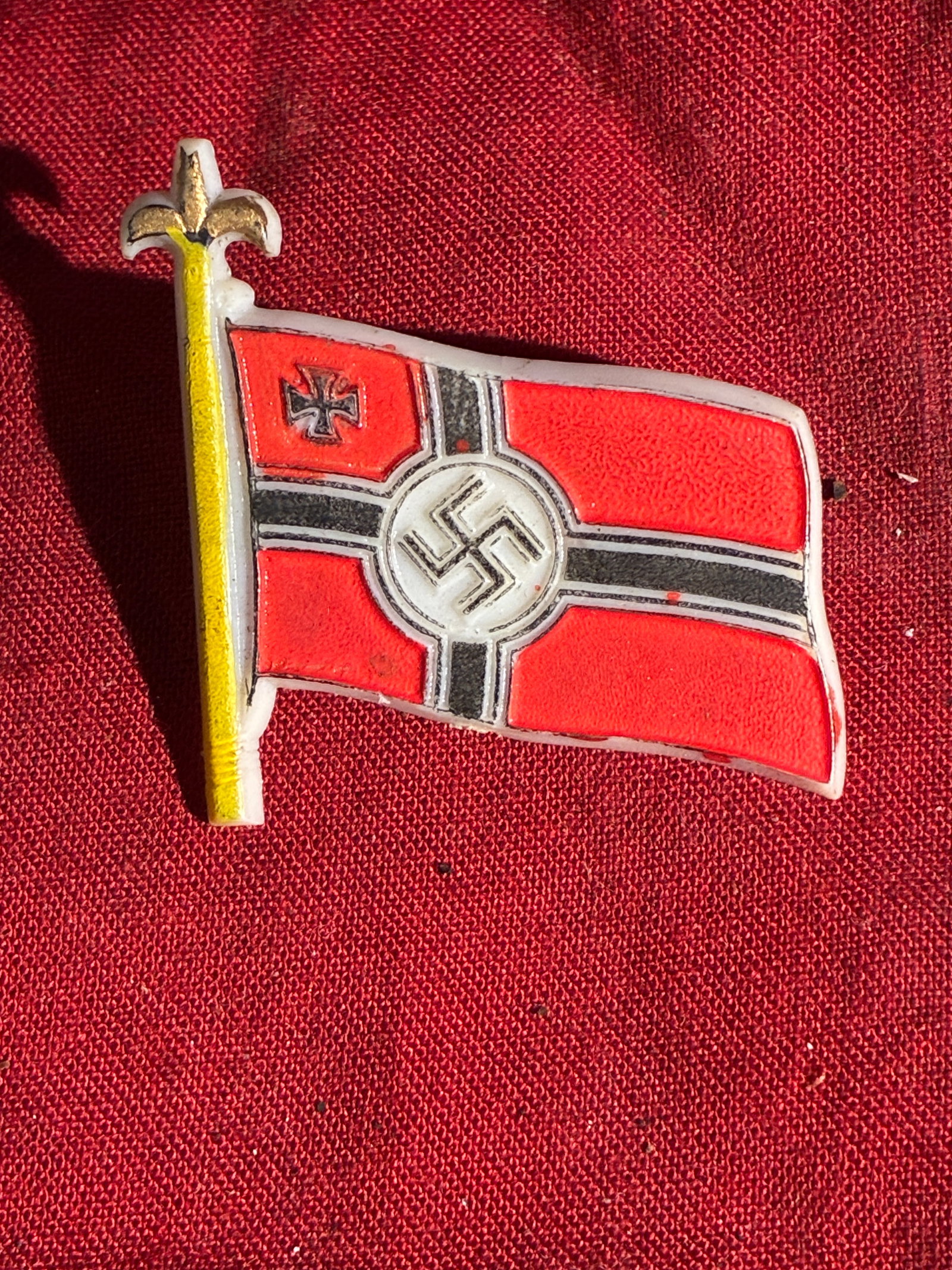 WW2 German Kriegsmarine War Ensign Commemorative Pin (c. 1935–1945): This small enamel lapel pin depicts the war ensign used by the German Kriegsmarine (Navy) during the period of the Third Reich. Such pins were unofficial commemorative or souvenir items, often private