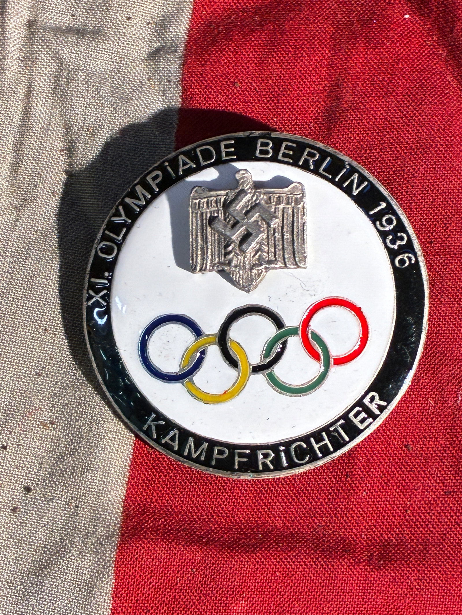 WW2 German Official Judge’s Badge – XI Olympic Games, Berlin 1936 By RZM SS: This badge was issued to competition judges (Kampfrichter) at the 1936 Summer Olympics held in Berlin, Germany. The front features the Olympic rings beneath the German national emblem of the period, w