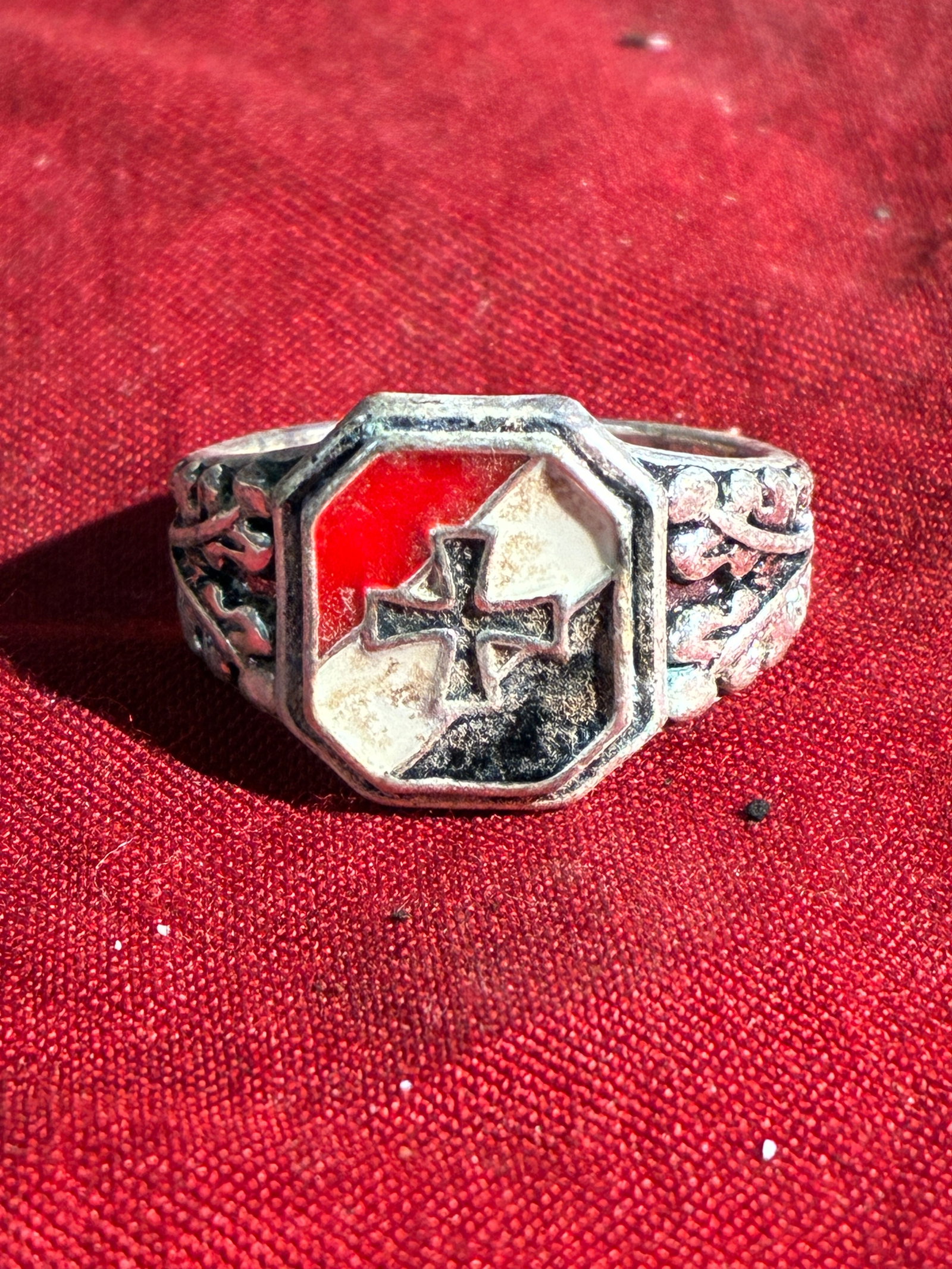 WW2 German Patriotic Souvenir Ring with Iron Cross Motif (c. 1930s–1940s): This small cast-metal ring features a shield-shaped bezel decorated with a red-white-black enamel pattern and a stylized Iron Cross at center—imagery commonly used in patriotic and nationalist souve