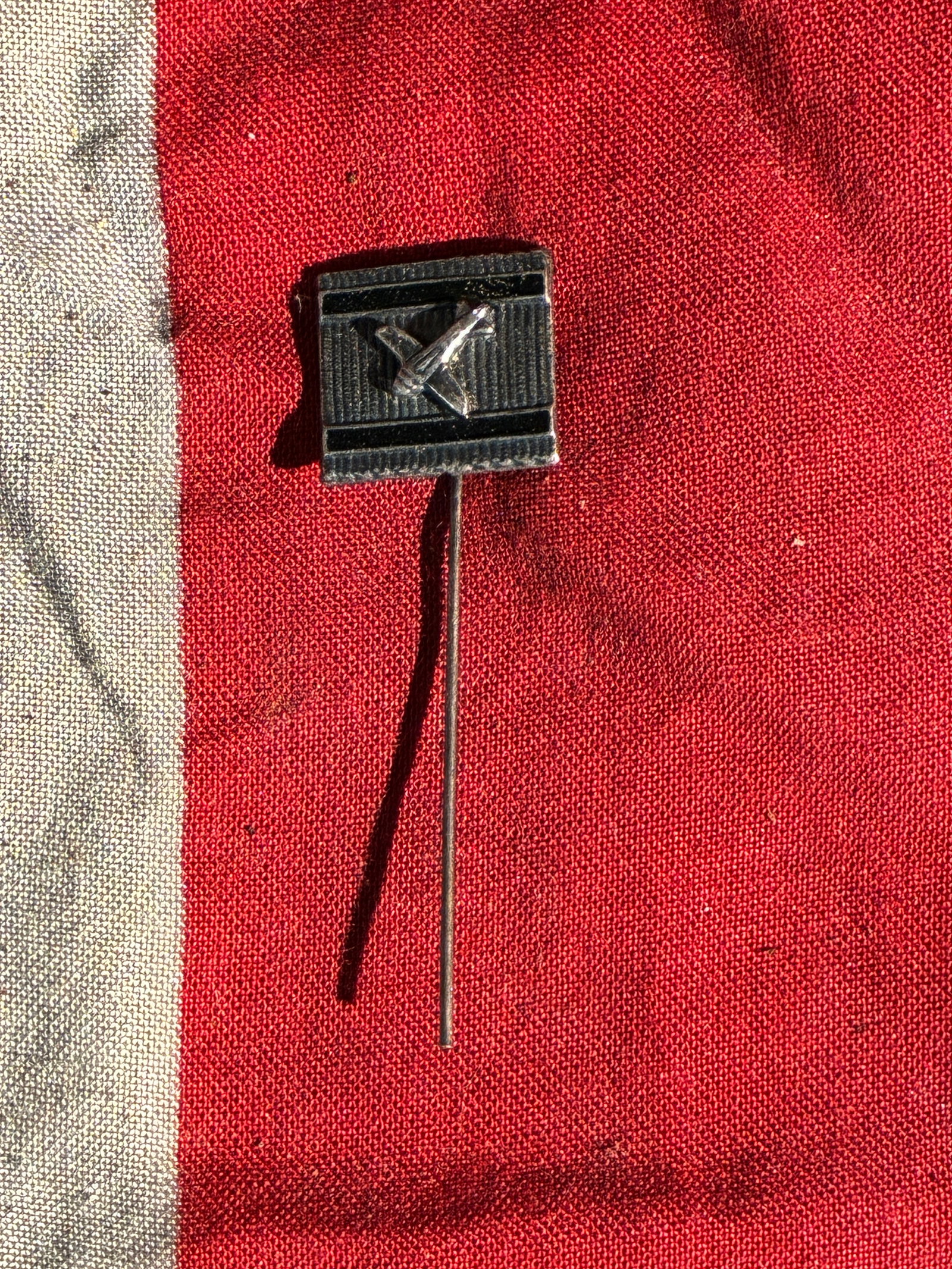 WW2 German Luftwaffe Ground-Crew “Fliegerhorst?? Stickpin (c. 1939–1945): This small stickpin features a stylized aircraft set against a black ribbed background, identifying it as an unofficial Third Reich–era souvenir or recognition item associated with Luftwaffe airfiel