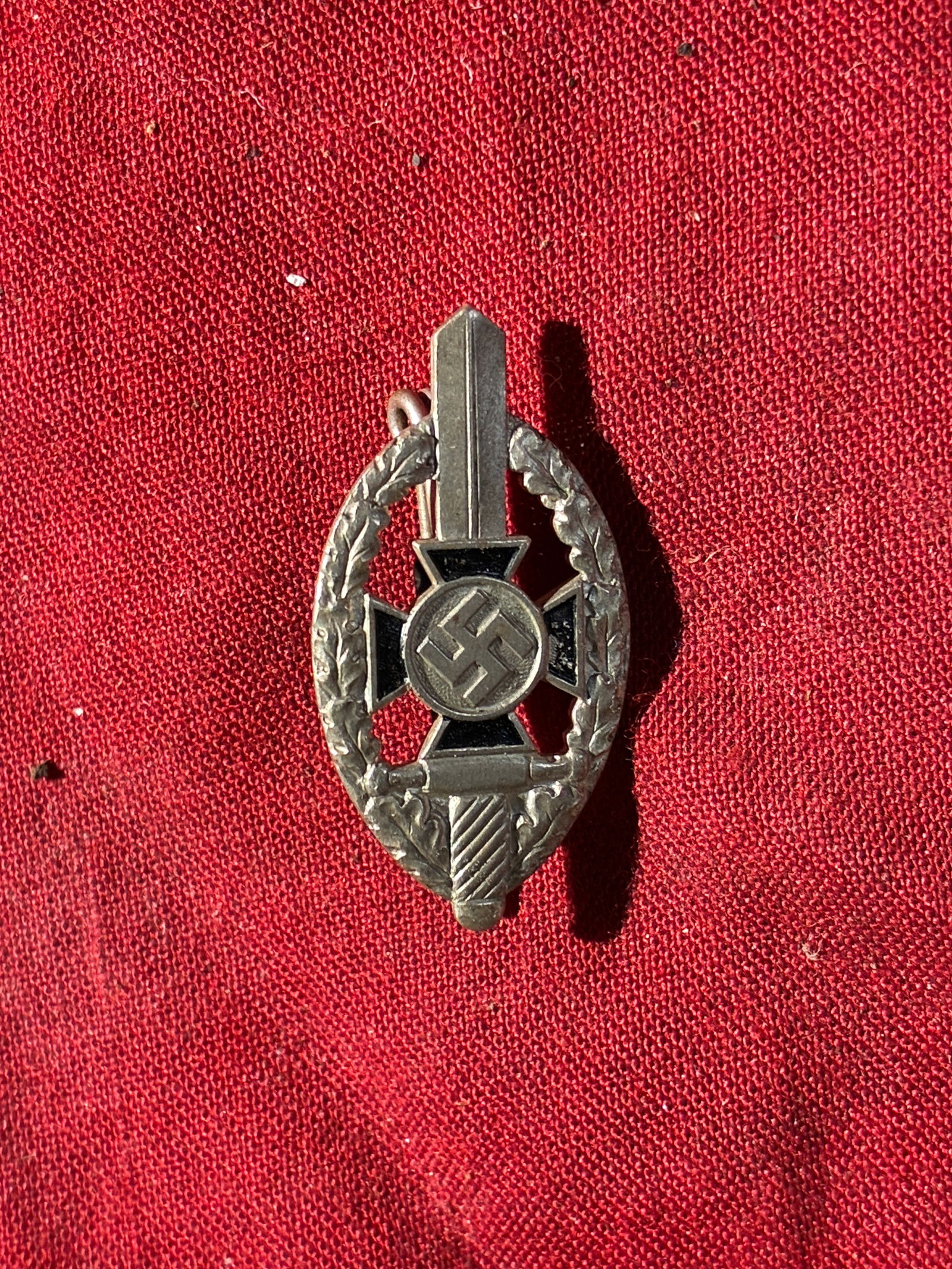 WW2 German Miniature SA Sports Badge (Stickpin Version), c. 1930s–1940s: This small stickpin represents the SA Sports Badge (SA-Sportabzeichen), a paramilitary award issued by the Sturmabteilung (SA) of Nazi Germany. The design features a central swastika imposed upon a st