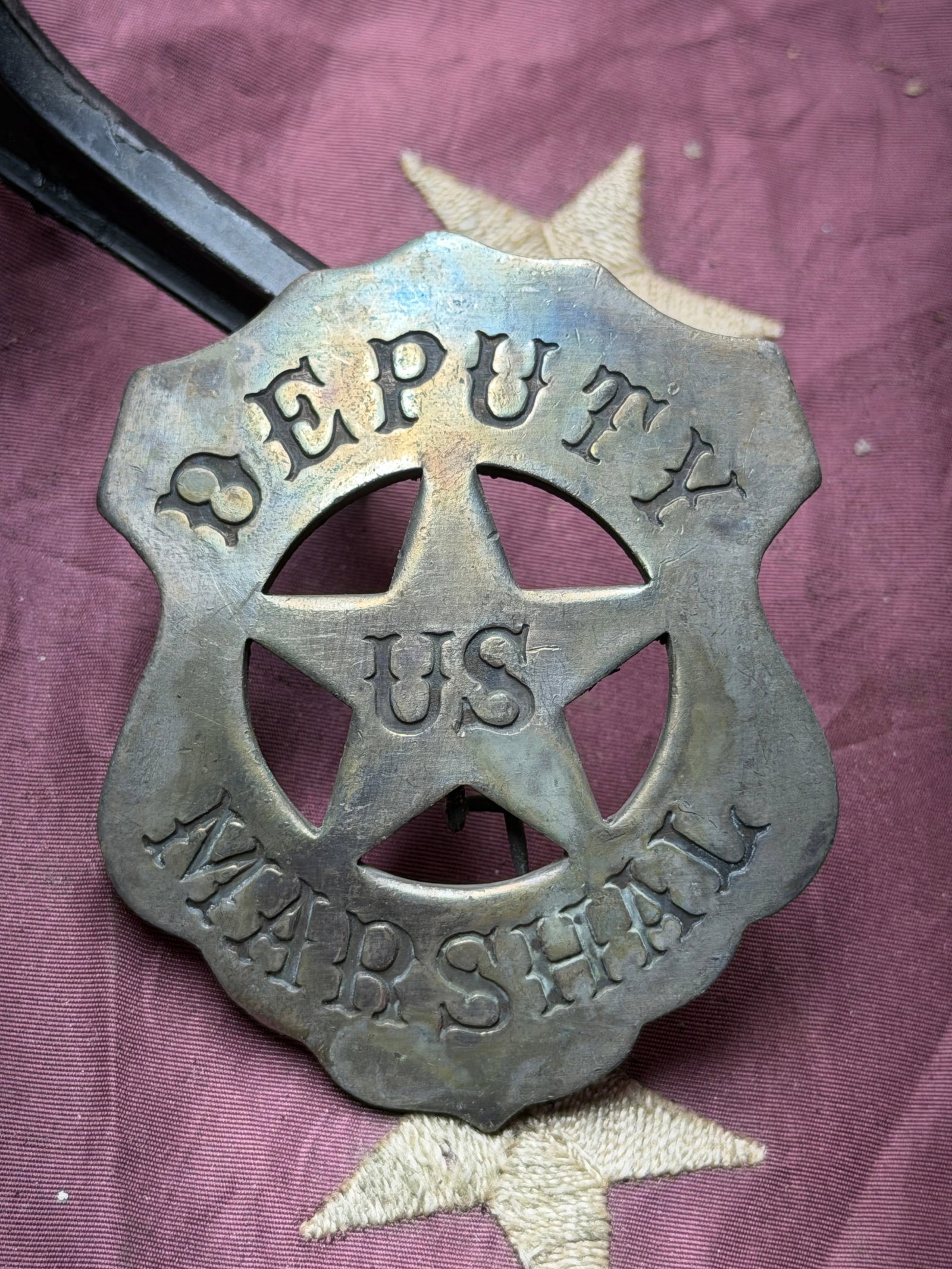 Deputy U.S. Marshal Badge: This metal badge represents the authority of a Deputy United States Marshal, a federal law enforcement officer serving under the U.S. Marshals Service. Featuring a five-pointed star within a scalloped