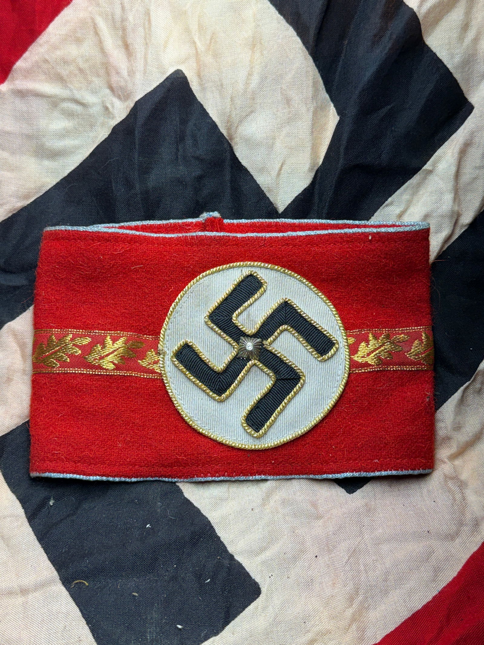 WW2 German National Socialist Party Political Leader Armband: This armband is a political insignia worn by officials of the National Socialist German Workers’ Party (NSDAP) during the Second World War. Constructed of red wool felt, it features a centrally appl
