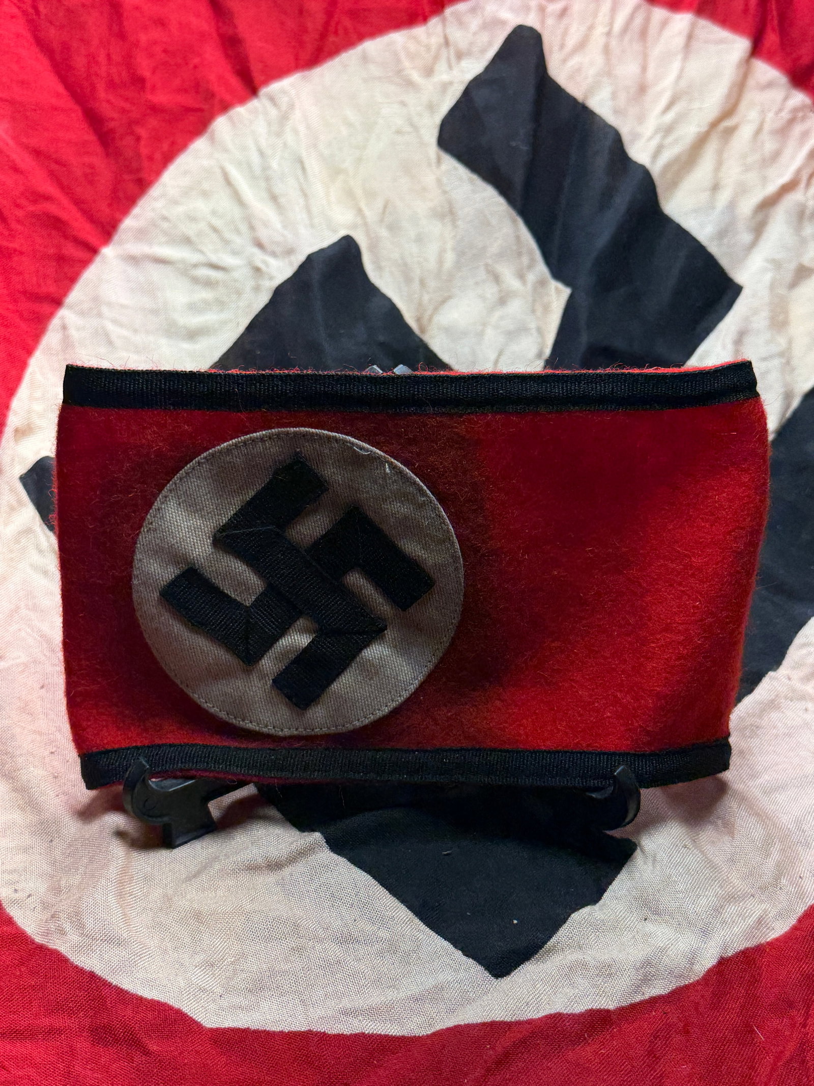 WW2 German Armband of Authority: SS Organizational Insignia, Third Reich: This object is a red wool armband bearing the black swastika within a white roundel, a standardized emblem of the National Socialist regime in Germany (1933–1945). Armbands of this type were worn on
