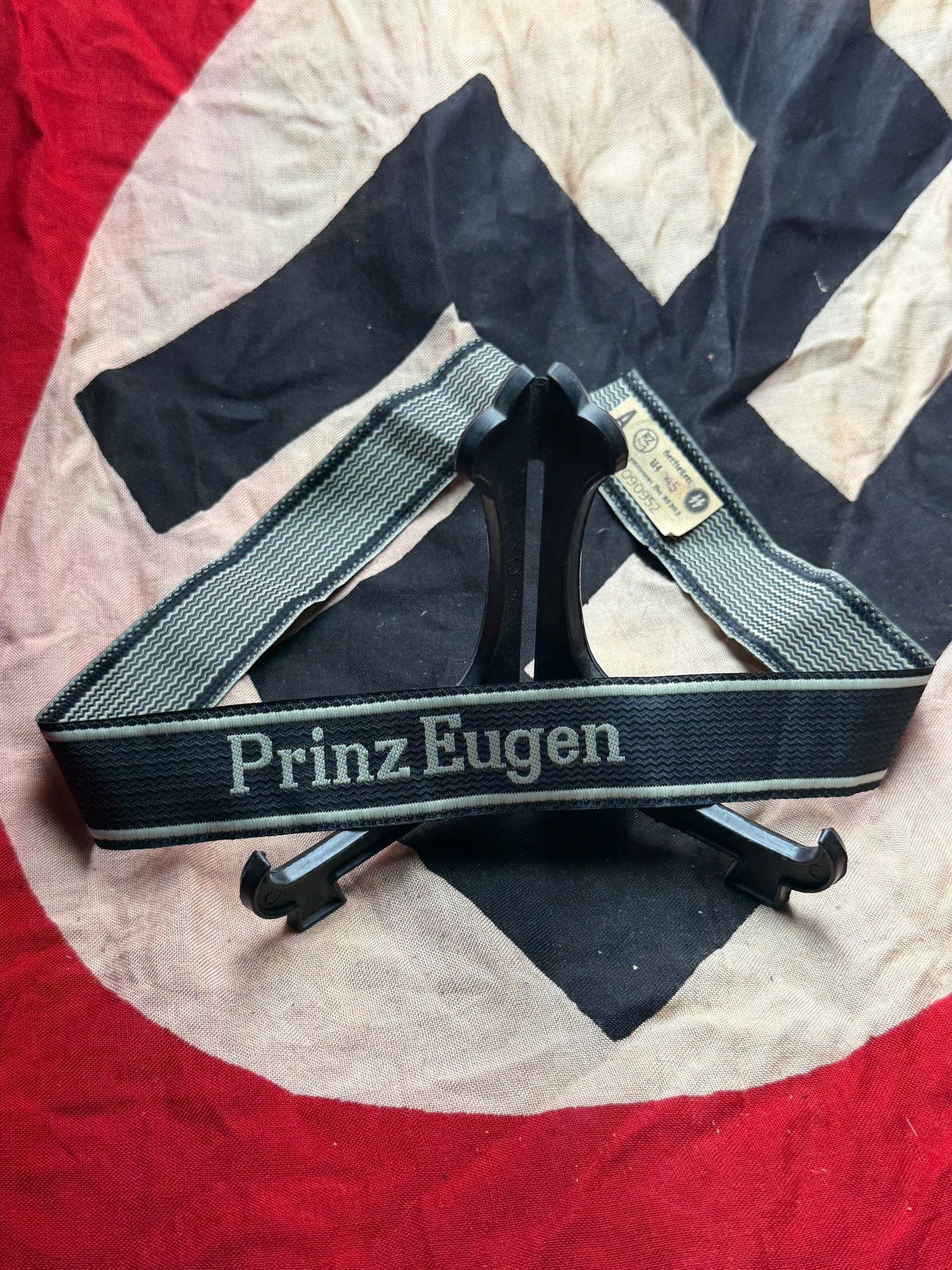 WW2 German Kriegsmarine Cuff Title “Prinz Eugen?? With RZM Paper Tag: This woven cloth cuff title bears the inscription “Prinz Eugen” and was worn on the lower sleeve of uniforms by members of the German Kriegsmarine assigned to the heavy cruiser Prinz Eugen. In