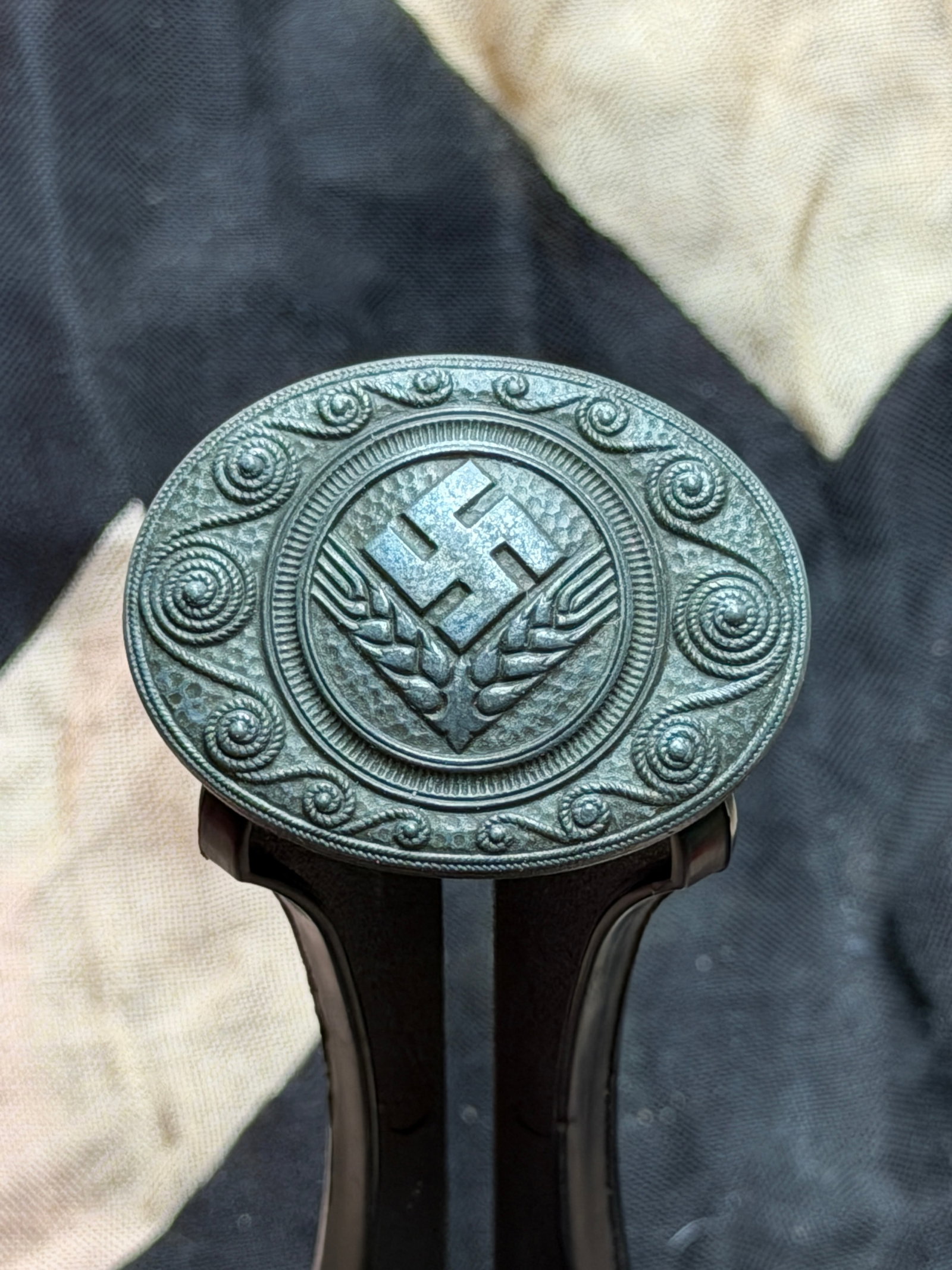 WW2 German Reichsarbeitsdienst der weiblichen Jugend (RADwJ) Service Brooch: This oval metal brooch is attributed to the Reichsarbeitsdienst der weiblichen Jugend (RADwJ), the female branch of the Reich Labor Service in Nazi Germany. The obverse displays a central swastika fla