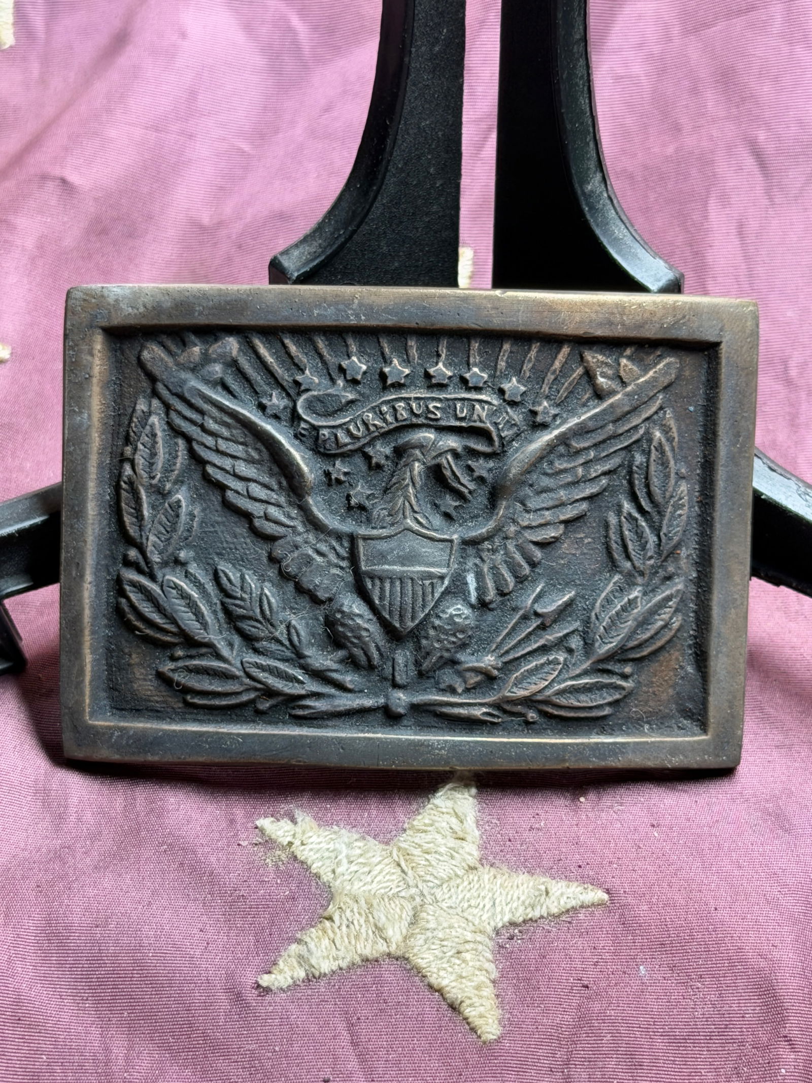 Civil War United States Militia Belt Plate (E Pluribus Unum): This rectangular brass belt plate features an American eagle with outstretched wings clutching a shield, surrounded by laurel branches and topped with a banner bearing the national motto “E Pluribus