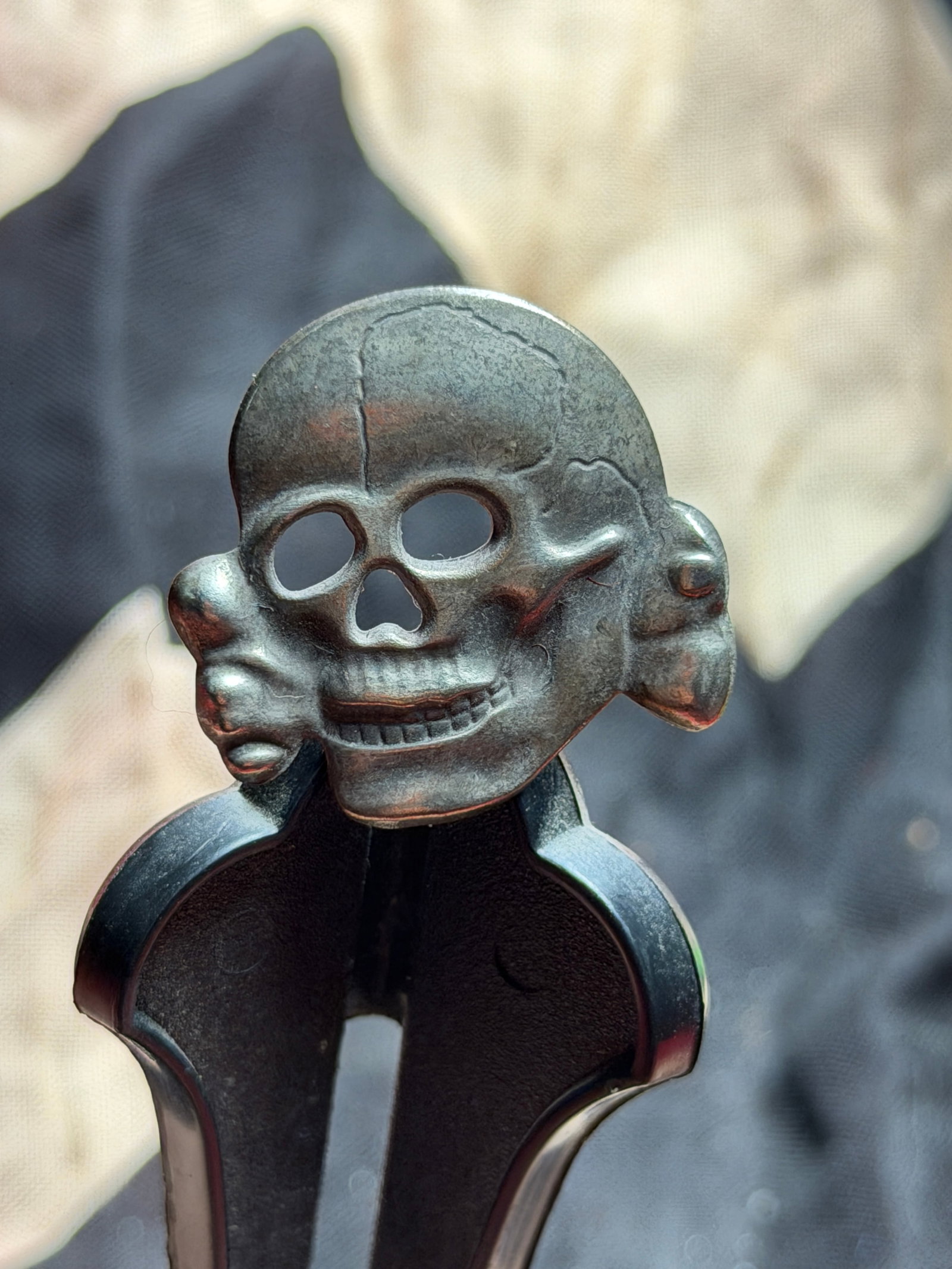 WW2 German Totenkopf Cap Insignia (Death’s Head), Waffen-SS: This metal cap insignia depicts the Totenkopf (“Death’s Head”), a skull motif historically associated with German military units and, during the Second World War, most prominently with the W