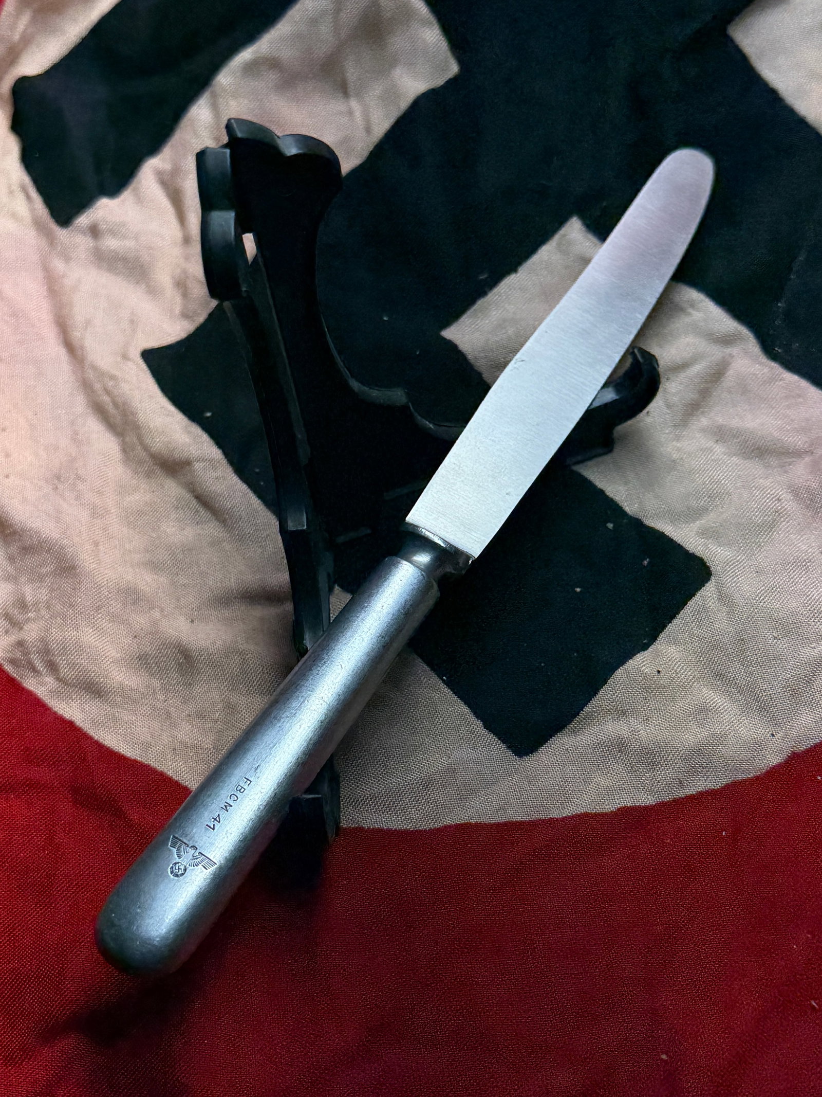 WW2 German Field Utility Knife with State Insignia: This metal-handled utility knife dates to the period of the Second World War and bears a stamped state emblem on the handle, along with a maker’s code and quality marking on the blade. Compact and f
