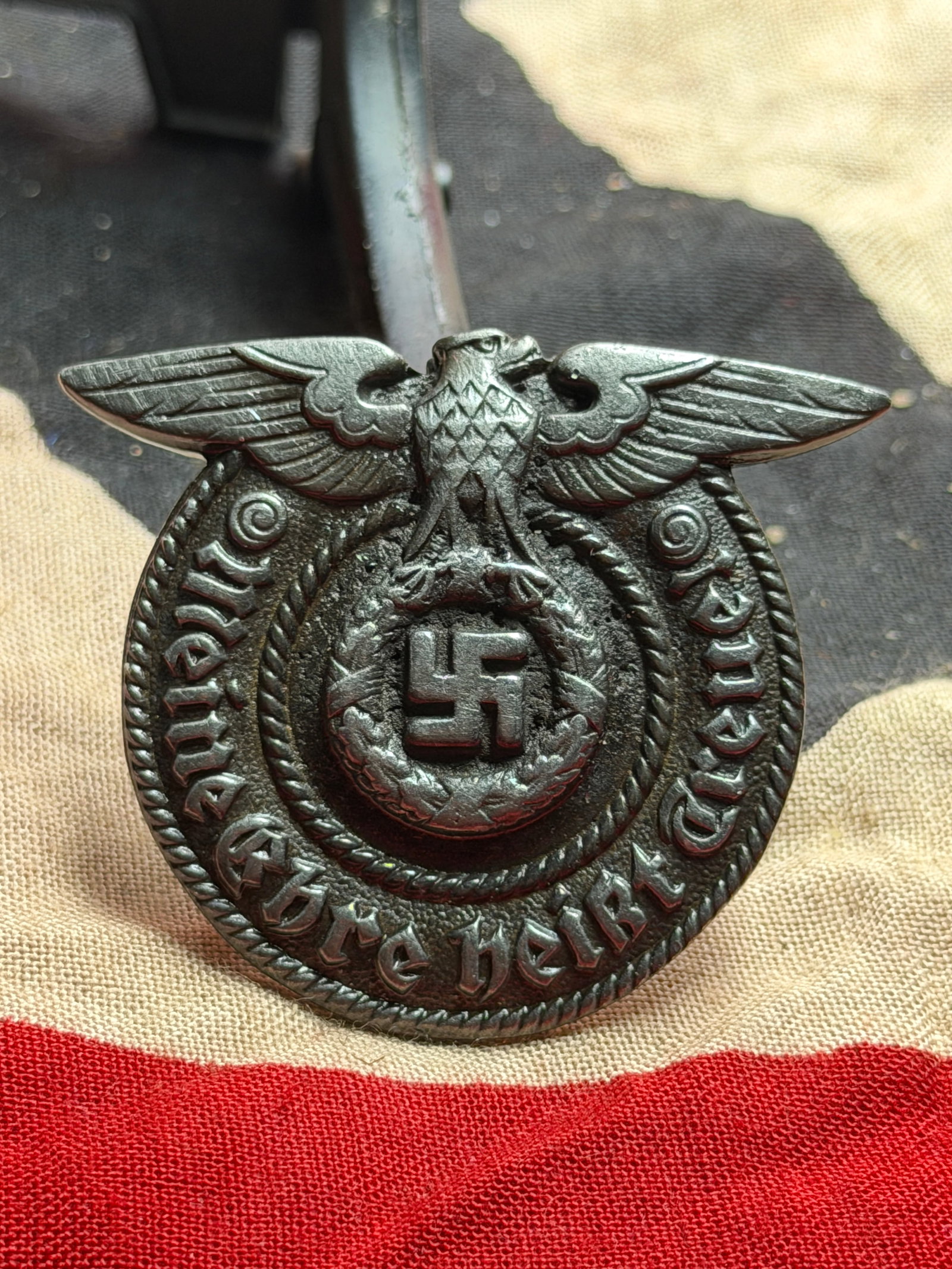 WW2 German Police Cap Eagle and Wreath Insignia (Polizei Hoheitsabzeichen), Third Reich Period, c.: This metal insignia is a German Ordnungspolizei (Order Police) cap badge from the Third Reich period, produced between approximately 1936 and 1945. The badge features the national eagle with outstretc