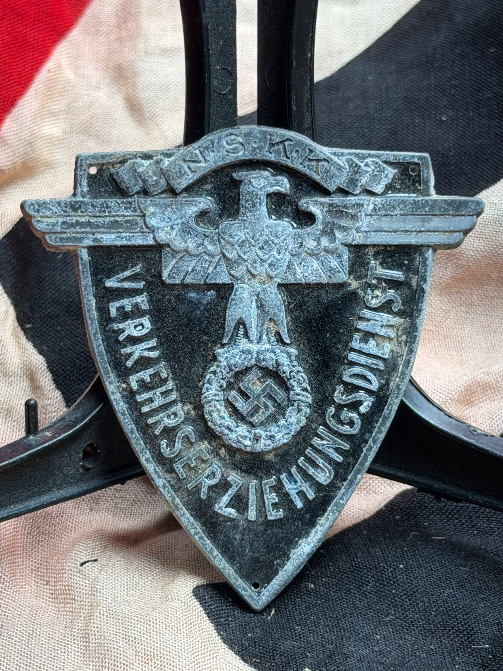 WW2 German Verkehrserziehungsschild der NS-Zeit (Traffic Education Badge): This cast-metal shield badge dates to the Third Reich period (c. 1933–1945) and bears the inscription “NSKZ – Verkehrserziehung” (“Traffic Education”), surmounted by the Reich eagl