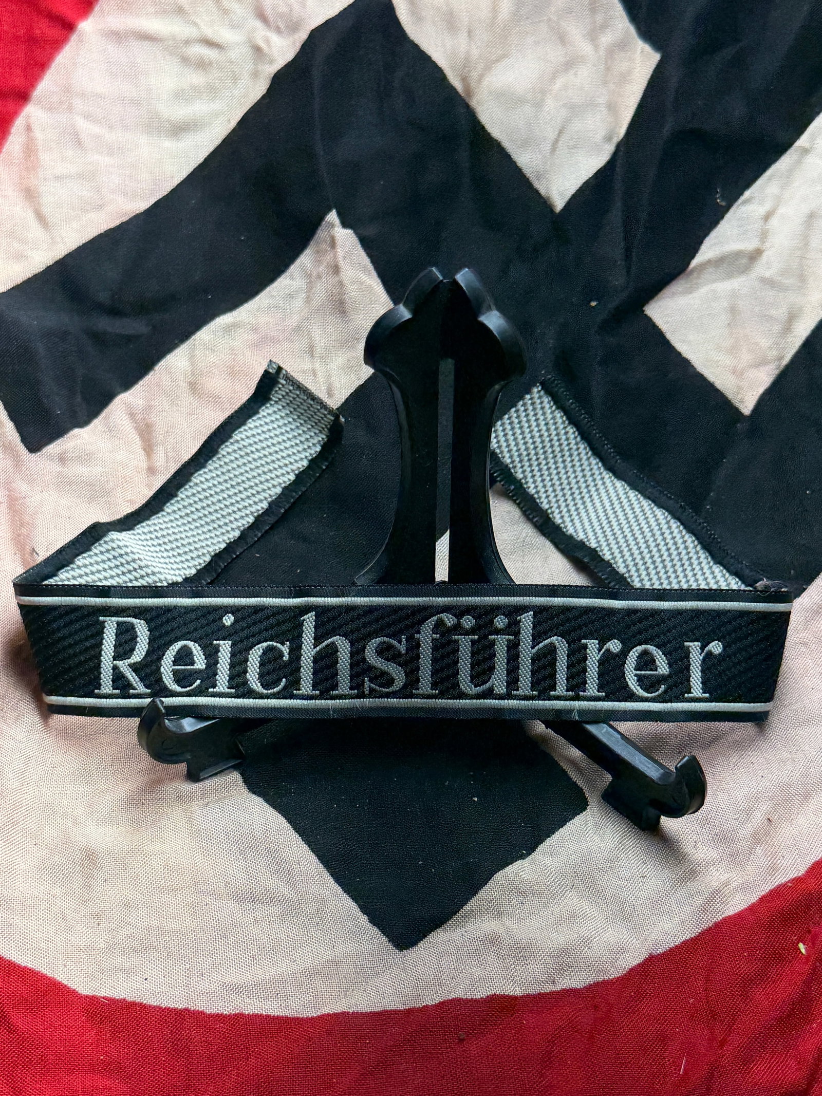 WW2 German Reichsführer Cuff Title (Ärmelstreifen): This woven cuff title bears the inscription “Reichsführer” in silver-grey thread on a black field, identifying the rank of Reichsführer-SS, the highest leadership position within the Schutzs