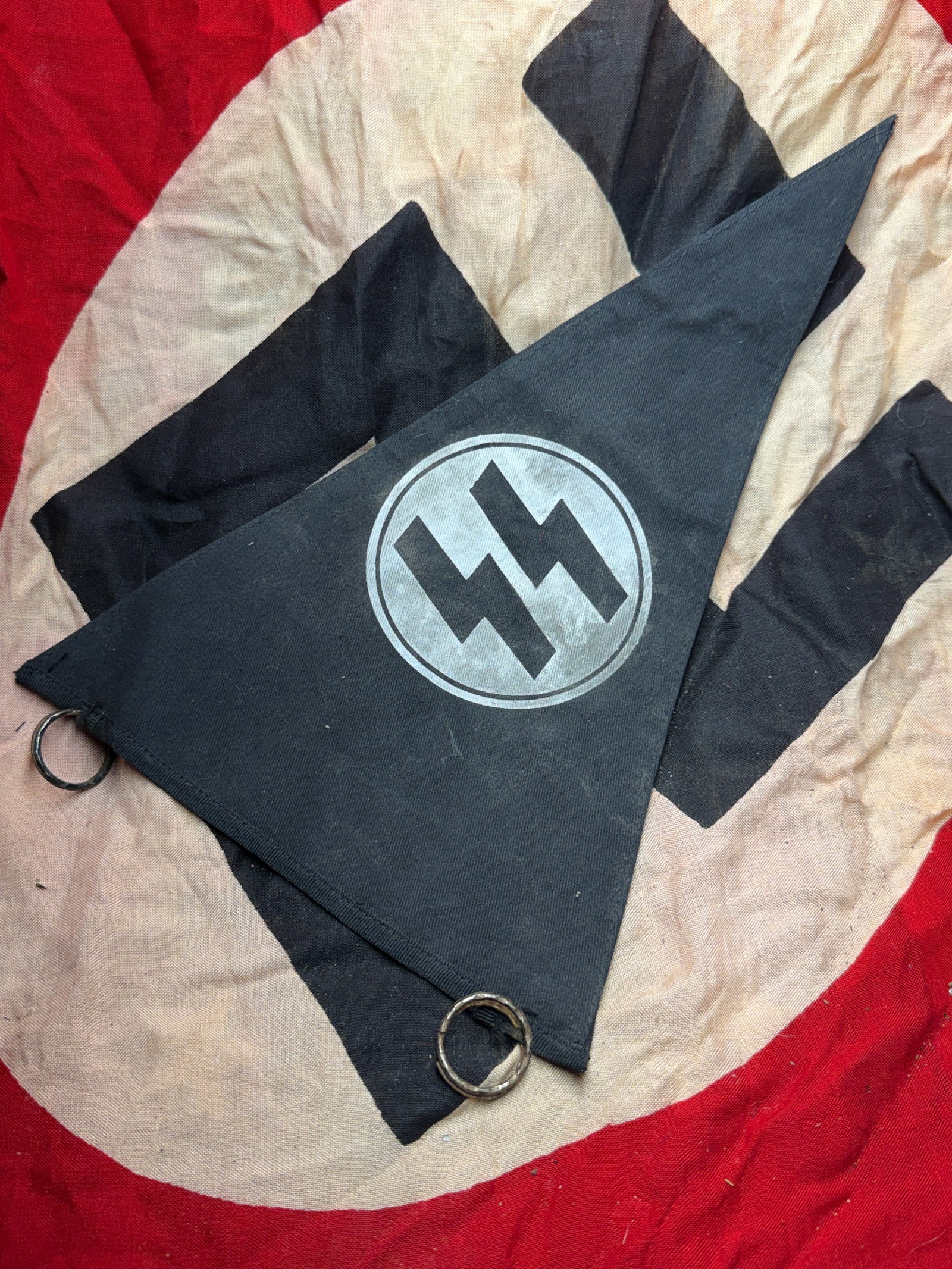 WW2 German SS Vehicle or Unit Pennant (Waffen-SS): This triangular cloth pennant bears the runic “SS” emblem of the Schutzstaffel (SS), one of the principal organizations of the National Socialist state in Germany during the Second World War. 