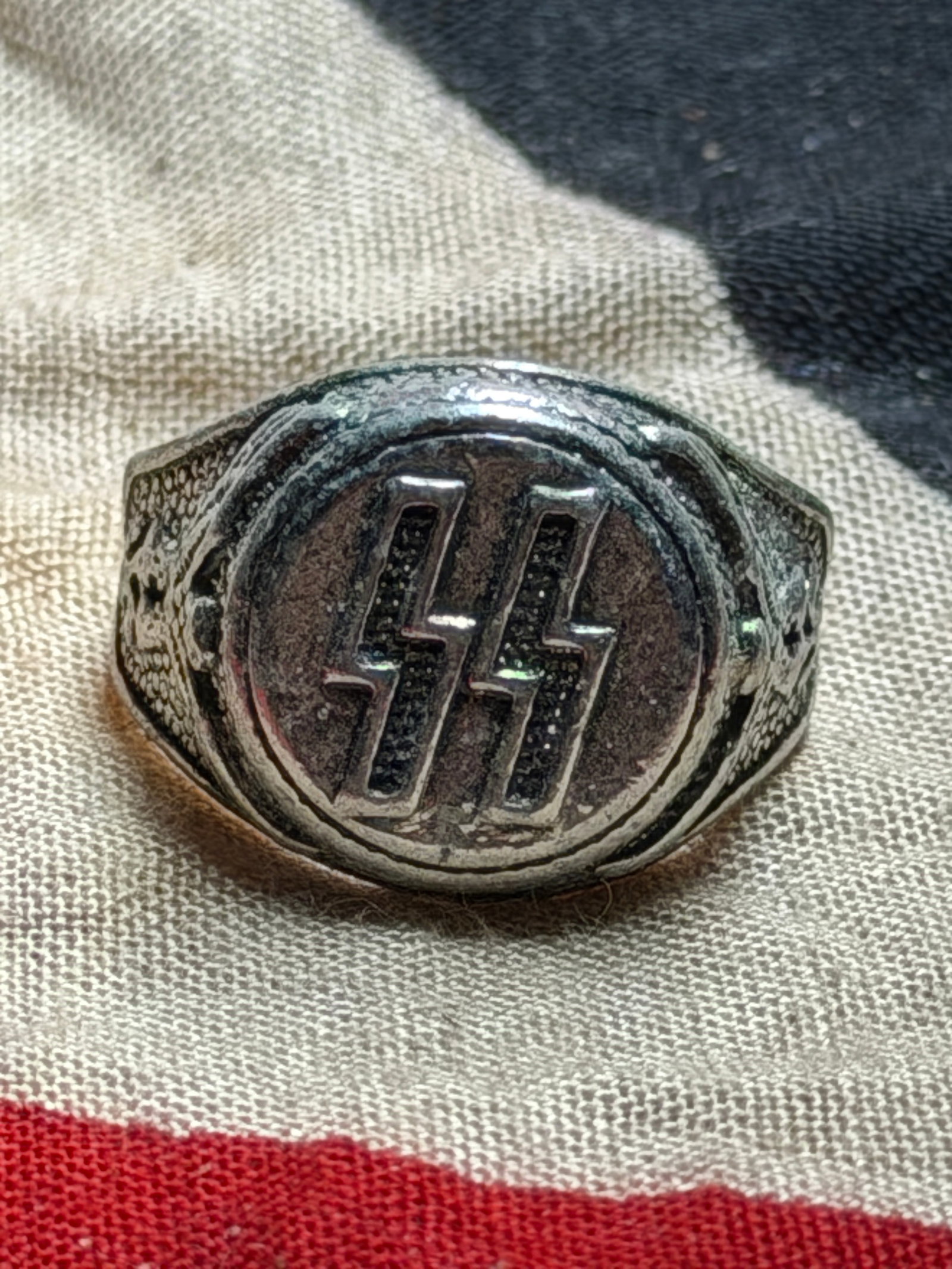 WW2 German Ring with SS Runes (Schutzstaffel): This metal ring bears the twin Sig runes emblem of the Schutzstaffel (SS), one of the principal organizations of the National Socialist state in Germany. The oval bezel displays the paired lightning-b