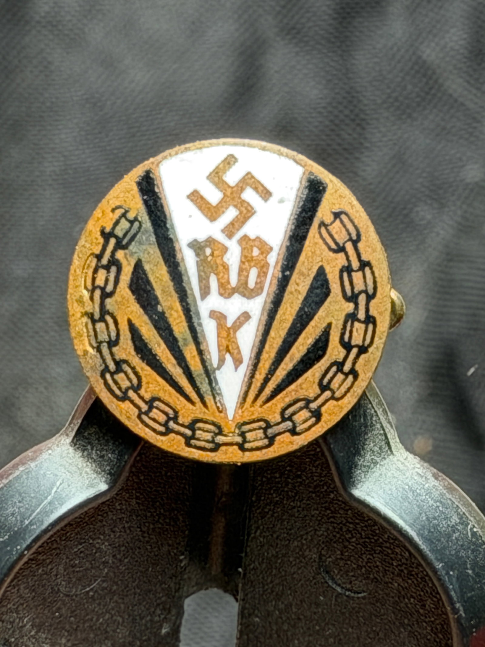 WW2 German RBK Membership Pin – Reichsbund der Kriegsbeschädigten: This circular enamel pin is a membership badge of the Reichsbund der Kriegsbeschädigten (RBK), the Reich League of War Disabled, an organization representing wounded veterans and war invalids in Germ
