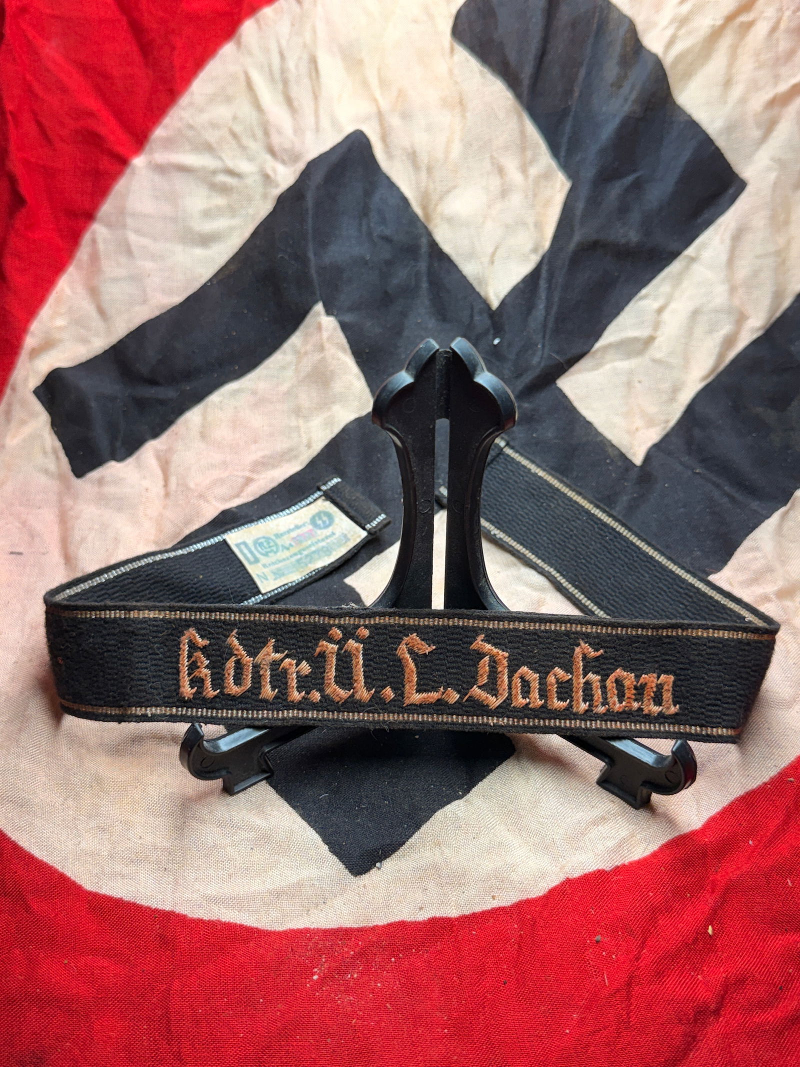 WW2 Waffen-SS Cuff Title Kdtr. Ü.L. Dachau Concentration Camp With RZM Paper Tag: WW2 Waffen-SS Cuff Title Kdtr. Ü.L. Dachau Concentration Camp With RZM Paper Tag. An ultra rare find that is in mint overall shape and condition with a beautiful overall patina. Shows good wear and u