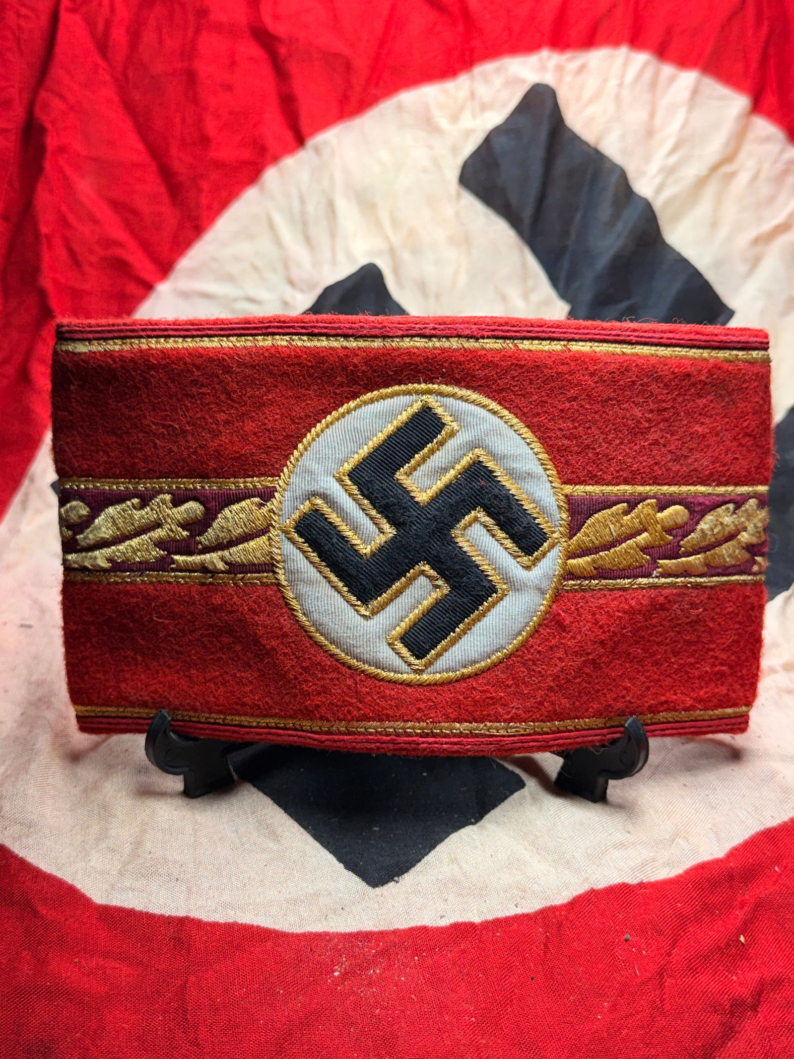 WW2 German National Socialist Party Armband With RZM Paper Tag: This armband is a German National Socialist Party (NSDAP) insignia from the World War II era with the RZM maker marks tag, identifiable by its red wool construction, centrally applied white roundel, a