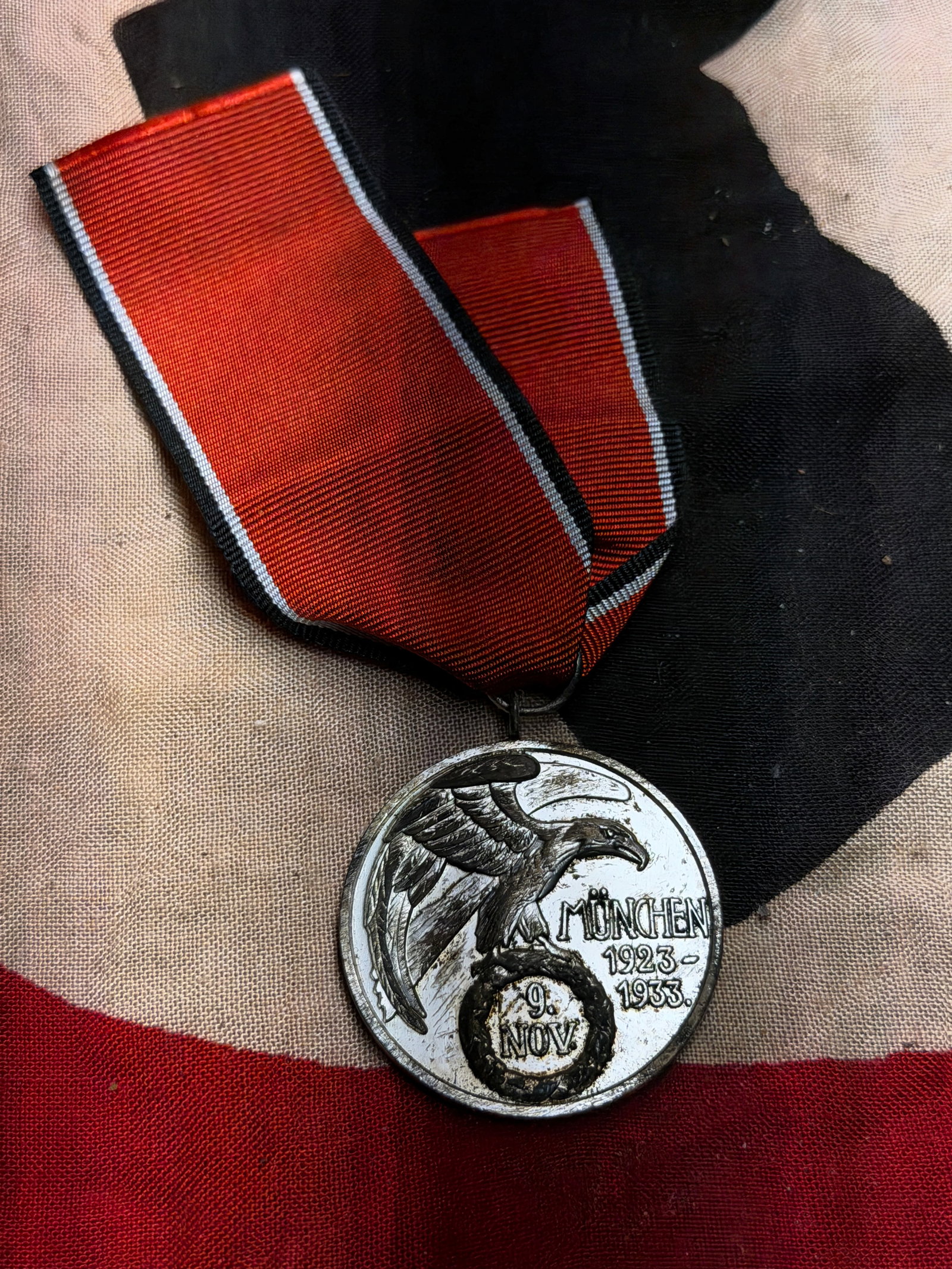 WW2 German NSDAP “Munich 1923–1933?? Commemorative Medal (9 November Medal): This circular medal is a German National Socialist commemorative award issued to mark the tenth anniversary of the failed Beer Hall Putsch of 9 November 1923 in Munich. The obverse depicts an eagle gr