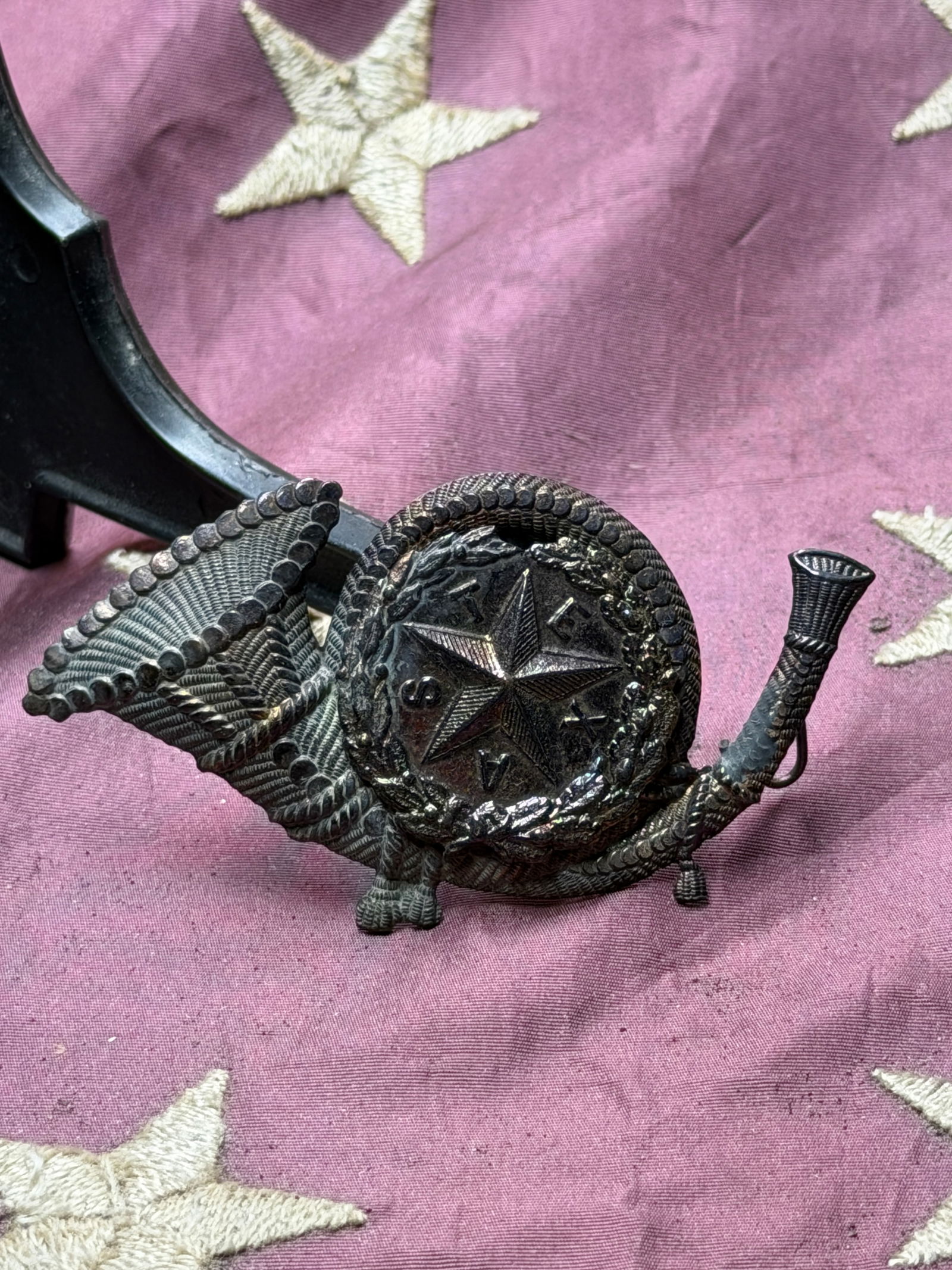 Texas Lone Star Infantry Hat Insignia, Civil War Era (1861–1865): This cast-metal hat insignia features the Texas Lone Star encircled by a wreath and flanked by crossed infantry horns, identifying it as an emblem associated with Texas infantry service during the Ame