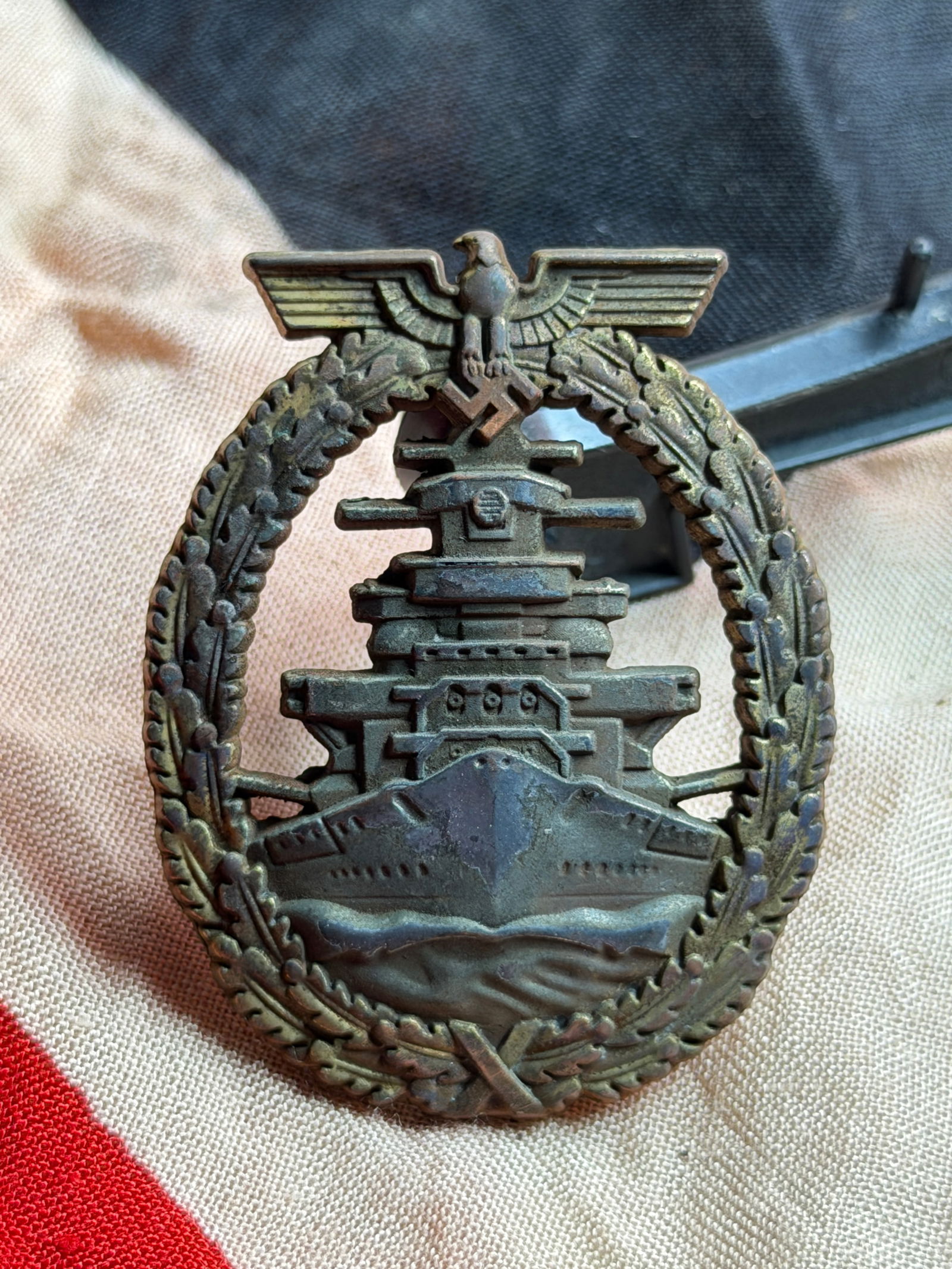 WW2 German Kriegsmarine High Seas Fleet Badge (Flottenkriegsabzeichen): This cast-metal badge is identified as a German Kriegsmarine High Seas Fleet Badge, instituted in 1941 during the Second World War. The design features a stylized German capital ship emerging from the