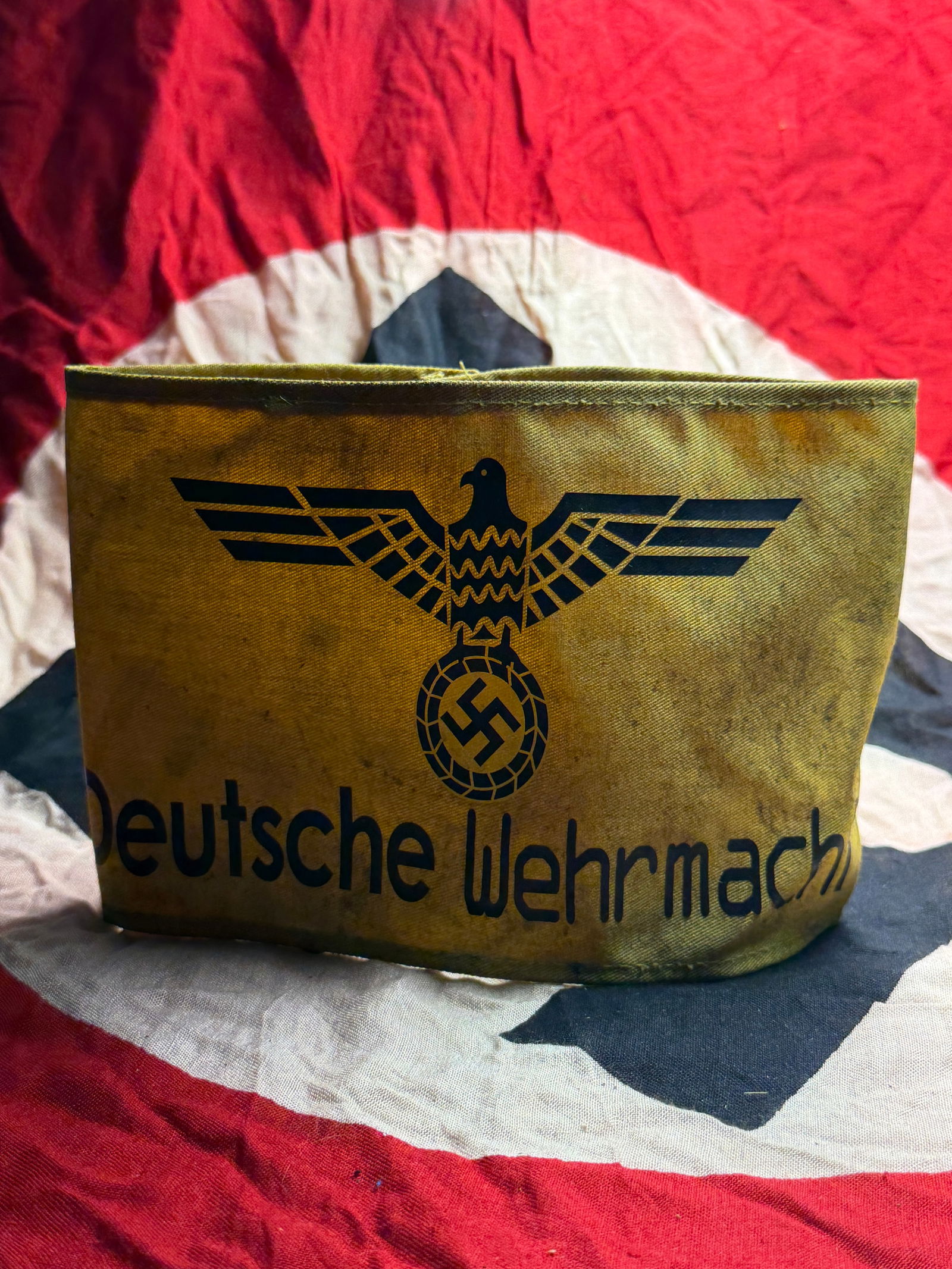 WW2 German Army (Wehrmacht) Armband/Armbinde: This textile armband bears the printed inscription “Deutsche Wehrmacht” beneath a stylized national eagle clutching a wreath enclosing a swastika, the official emblem of the German armed force