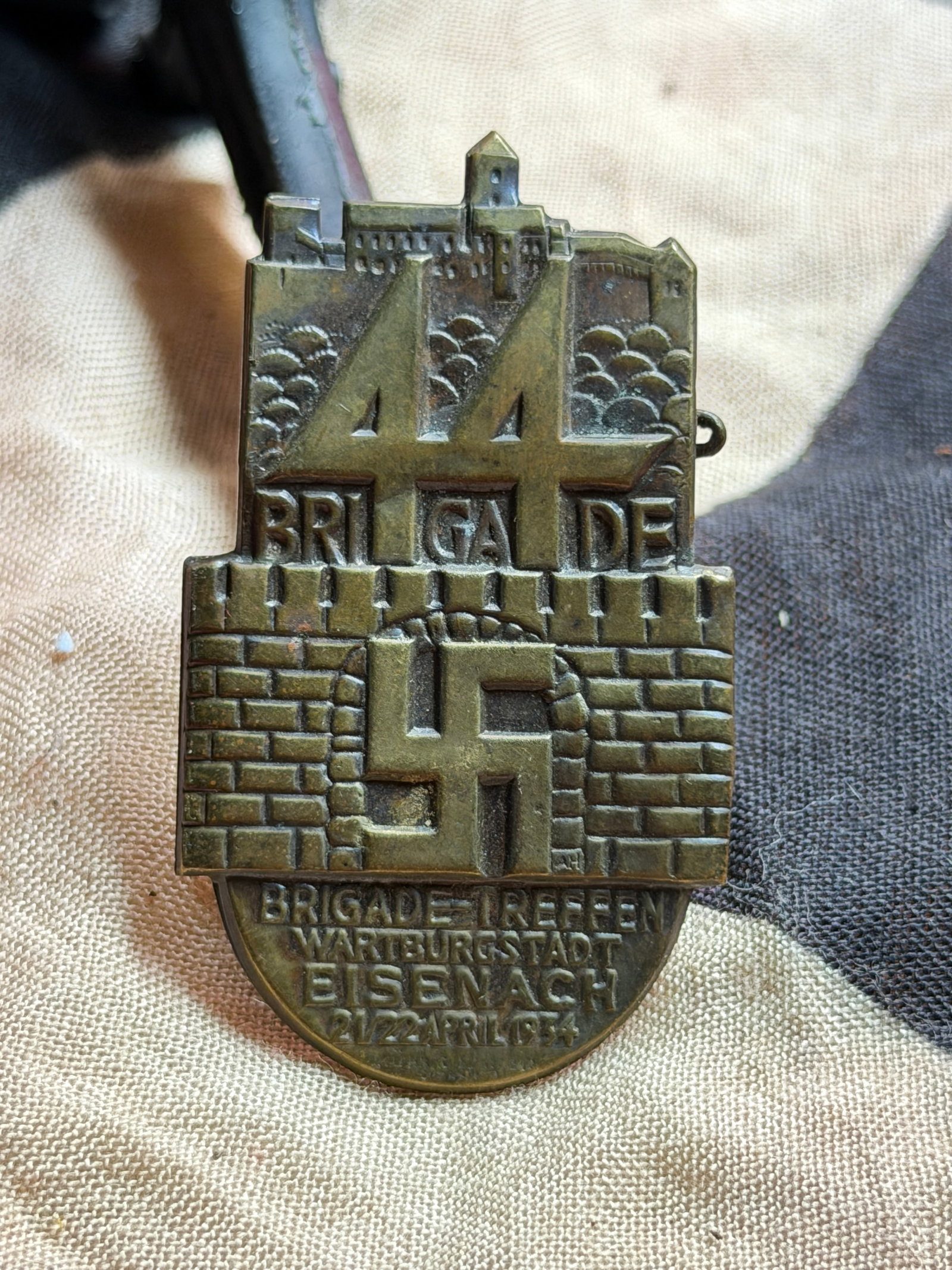 WW2 German Commemorative Badge: 44th SA Brigade Meeting, Wartburgstadt Eisenach (1934): This metal commemorative badge was issued for the 44th Brigade gathering (Brigadetreffen) of the Sturmabteilung (SA), held in Wartburgstadt Eisenach, Germany, on 21–22 April 1934. The badge features