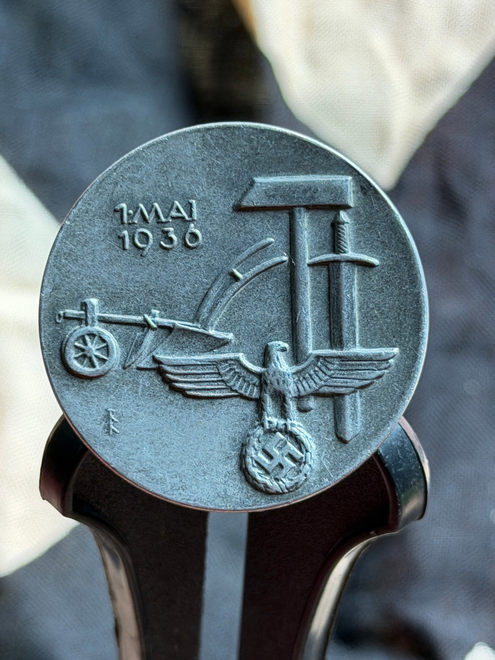 WW2 “Tag der Arbeit?? Commemorative Badge, Germany, 1 May 1936: This circular metal badge was issued in Germany to commemorate “Tag der Arbeit” (Day of Labor) on 1 May 1936, a national observance during the period of National Socialist rule. The obverse de