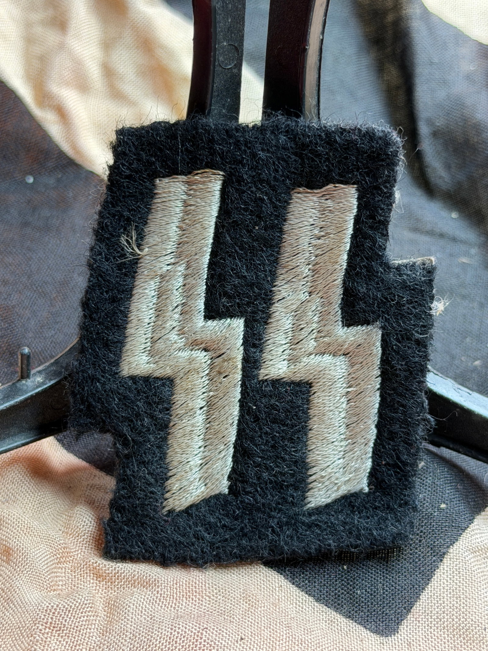 WW2 German SS “Sig Runes?? Sleeve Badge With RZM Label: This is an embroidered SS (Schutzstaffel) sleeve badge that dates to Nazi Germany, circa 1934–1945. The patch displays the double “Sig” (??) runes, embroidered in silver-gray thread on black