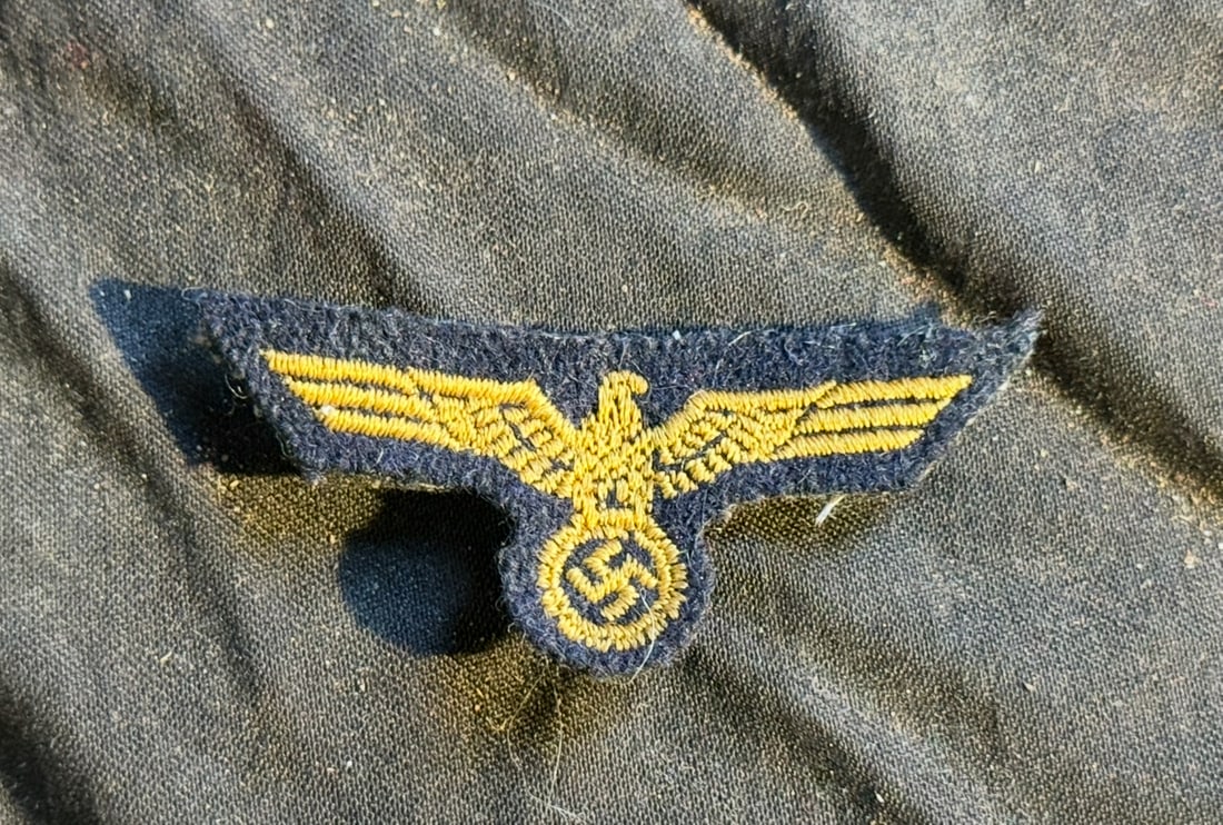 WW2 German Coastal Breast Eagle (Cloth Insignia): This embroidered cloth insignia depicts the coastal eagle clutching a wreath, executed in yellow thread on a dark blue wool backing. Such insignia were worn on coastal uniforms to denote branch affili