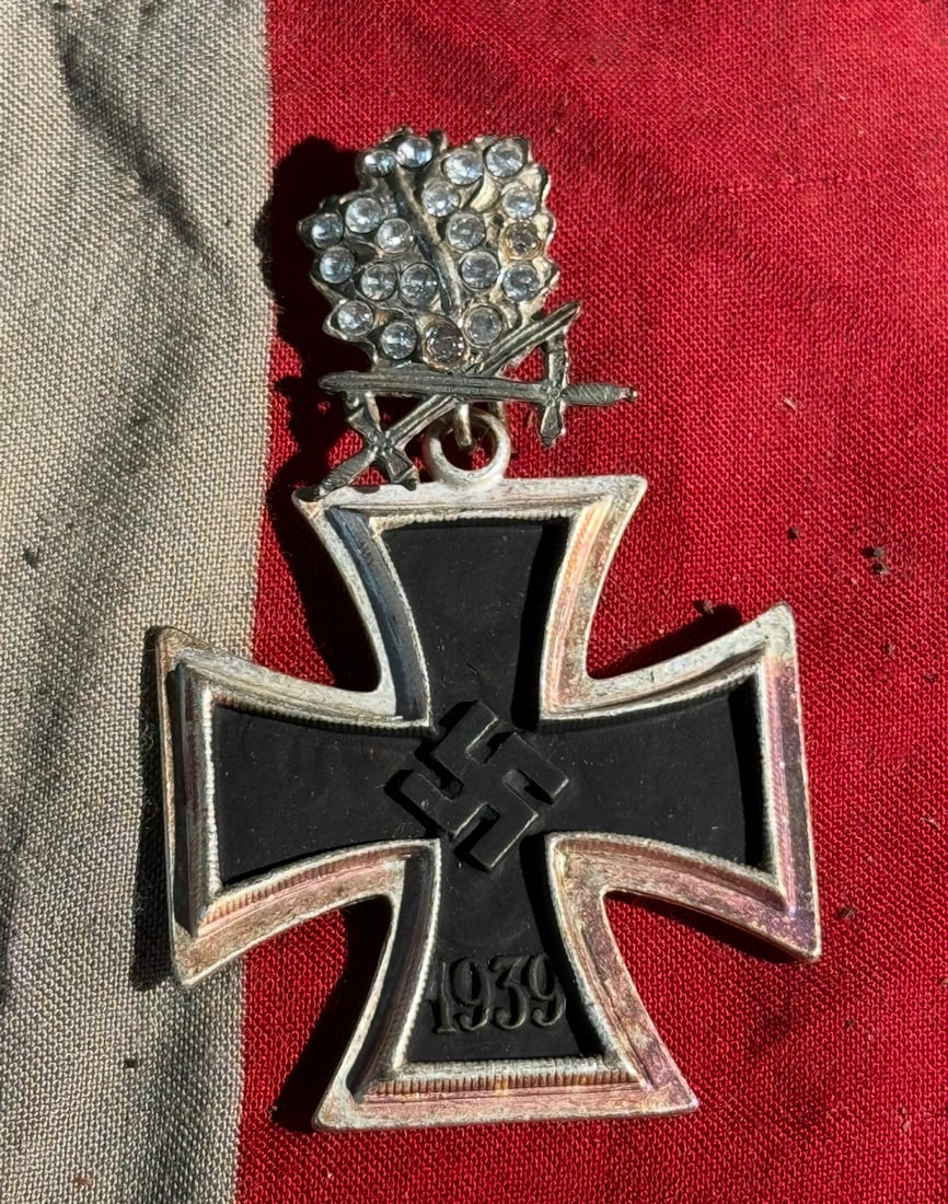 WW2 German Iron Cross, Second Class with Oak Leaves Swords and Diamonds: This object is a German Iron Cross, Second Class (Eisernes Kreuz II. Klasse), instituted in 1939, suspended from a highly decorative oak leaves, crossed swords, and diamond-studded embellishment. The