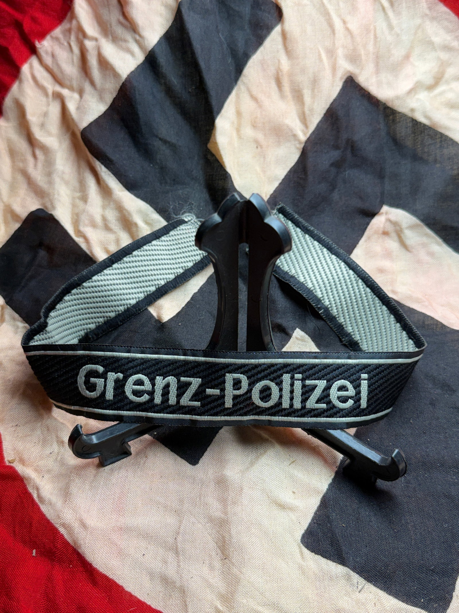 WW2 German Grenzpolizei Armband (Border Police Identification Band) Cuff Title Bevo Wuppertal: This woven armband is an identification insignia of the Grenzpolizei (German Border Police) during the Nazi era. Constructed of black wool with machine-woven silver-gray lettering reading “Grenz-Pol