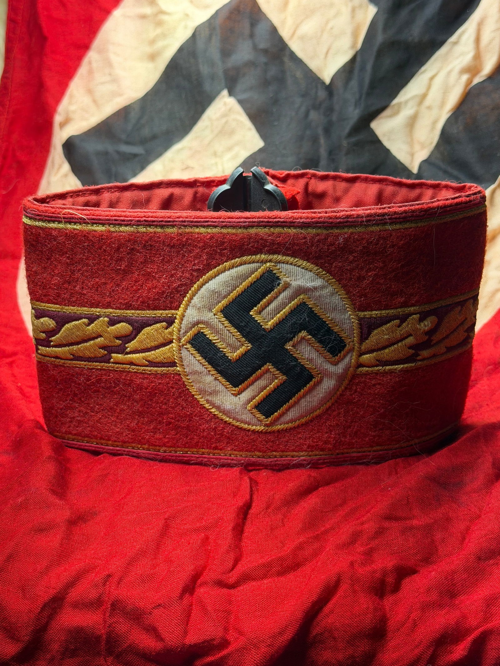 WW2 German NSDAP Gauleiter Armband, Nazi Germany, c. 1933–1945 With RZM Paper Tag: This red wool armband is identified as a high-ranking NSDAP Gauleiter armband, worn by senior regional leaders of the National Socialist German Workers’ Party. The central emblem features a black sw