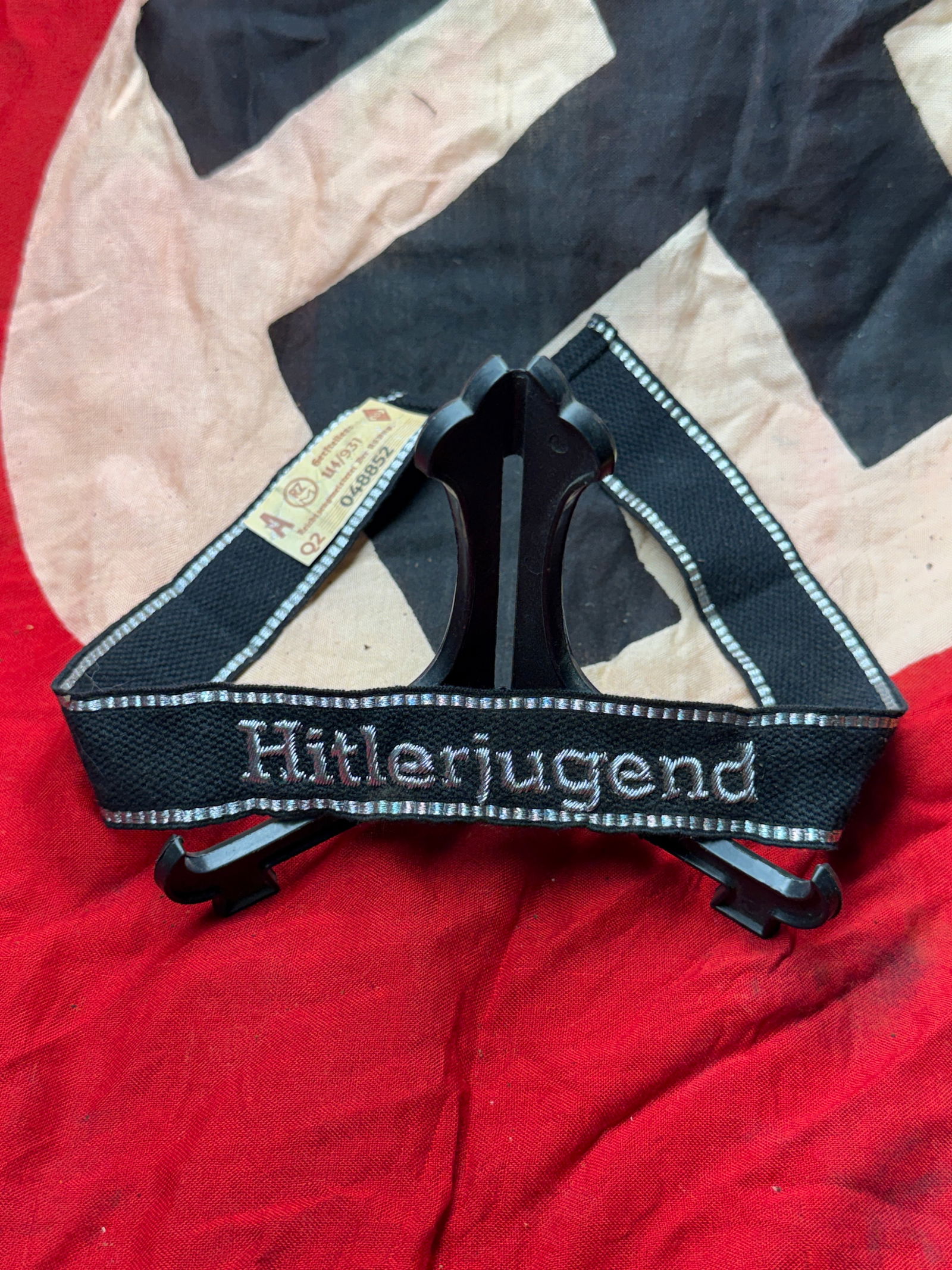 WW2 German Hitlerjugend Cuff Title with RZM Control Tag: This embroidered cuff title was worn by members of the Hitlerjugend (Hitler Youth), the National Socialist youth organization active in Germany from 1926 to 1945. Woven in black fabric with silver-gra