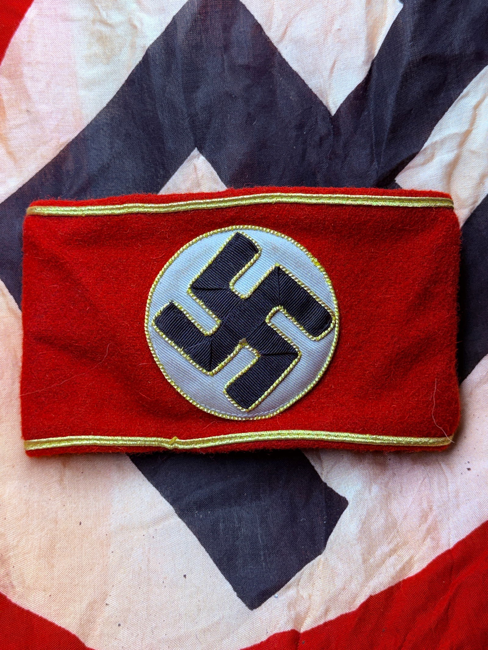 WW2 German National Socialist Party Armband with RZM Control Label: This red wool armband is an original Nationalsozialistische Deutsche Arbeiterpartei (NSDAP) uniform insignia worn in Nazi Germany between 1933 and 1945. The armband features a white circular field bea
