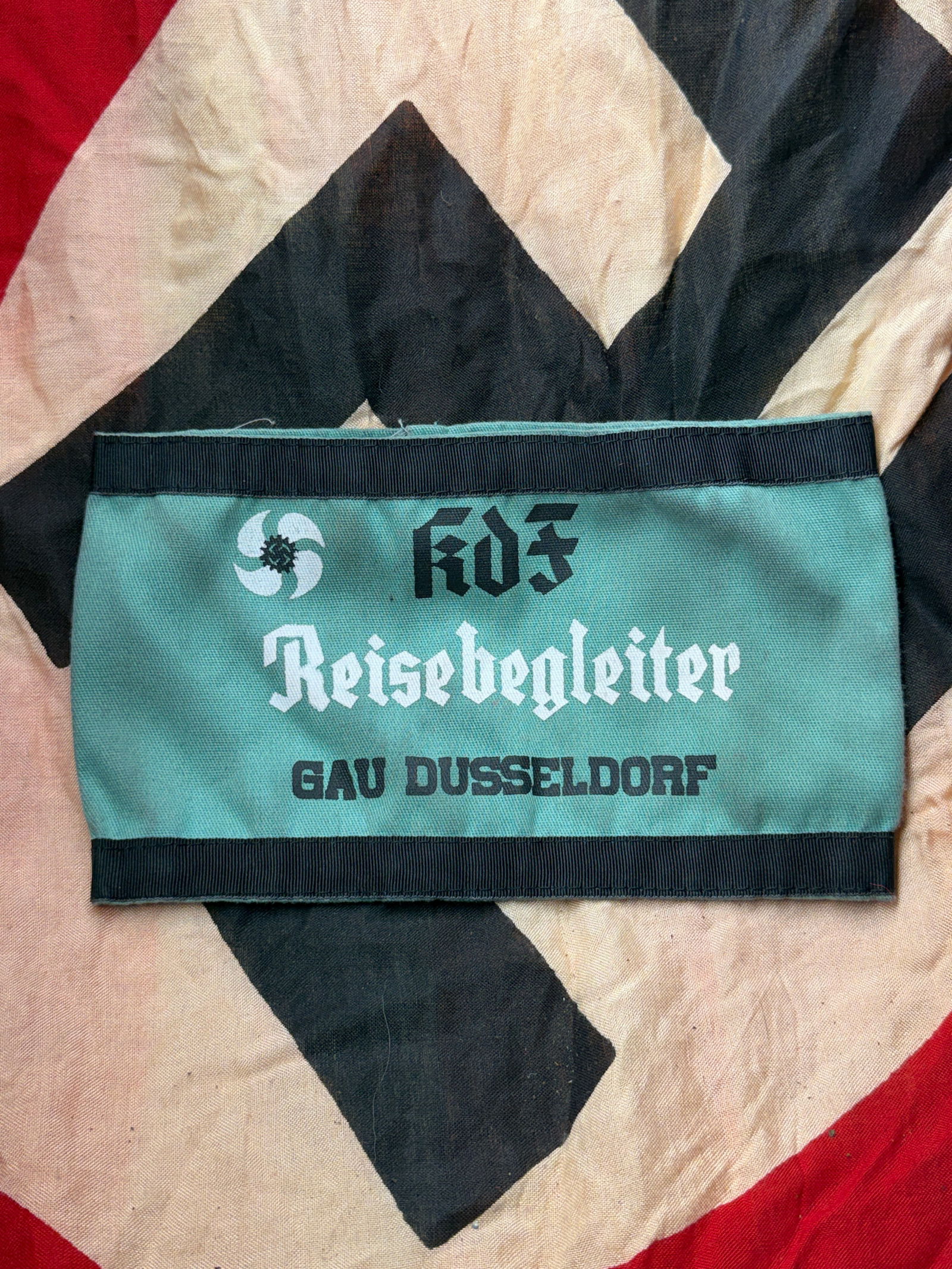 WW2 German NSDAP KdF “Reisebegleiter?? Armband – Gau Düsseldorf: This armband belonged to a Reisebegleiter (“travel escort”) of the National Socialist organization Kraft durch Freude (KdF – Strength Through Joy), assigned to Gau Düsseldorf. KdF was a mas