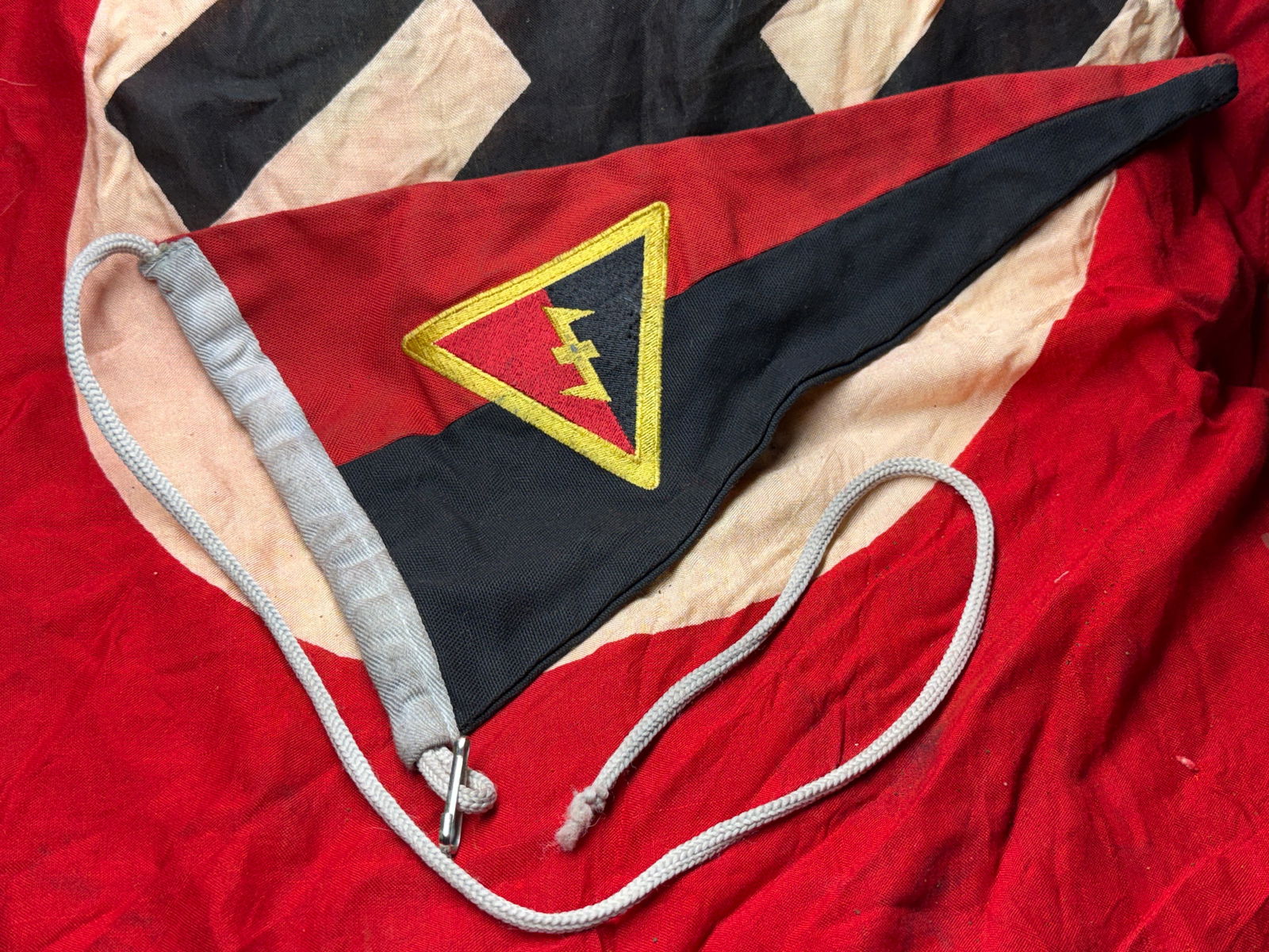 WW2 German Hitler Youth Unit Pennant (HJ Wimpel), Germany, c. 1936–1945: This triangular cloth pennant is an original organizational accessory associated with the Hitler Youth (Hitlerjugend), the state-sponsored youth movement of Nazi Germany. Constructed from red and blac