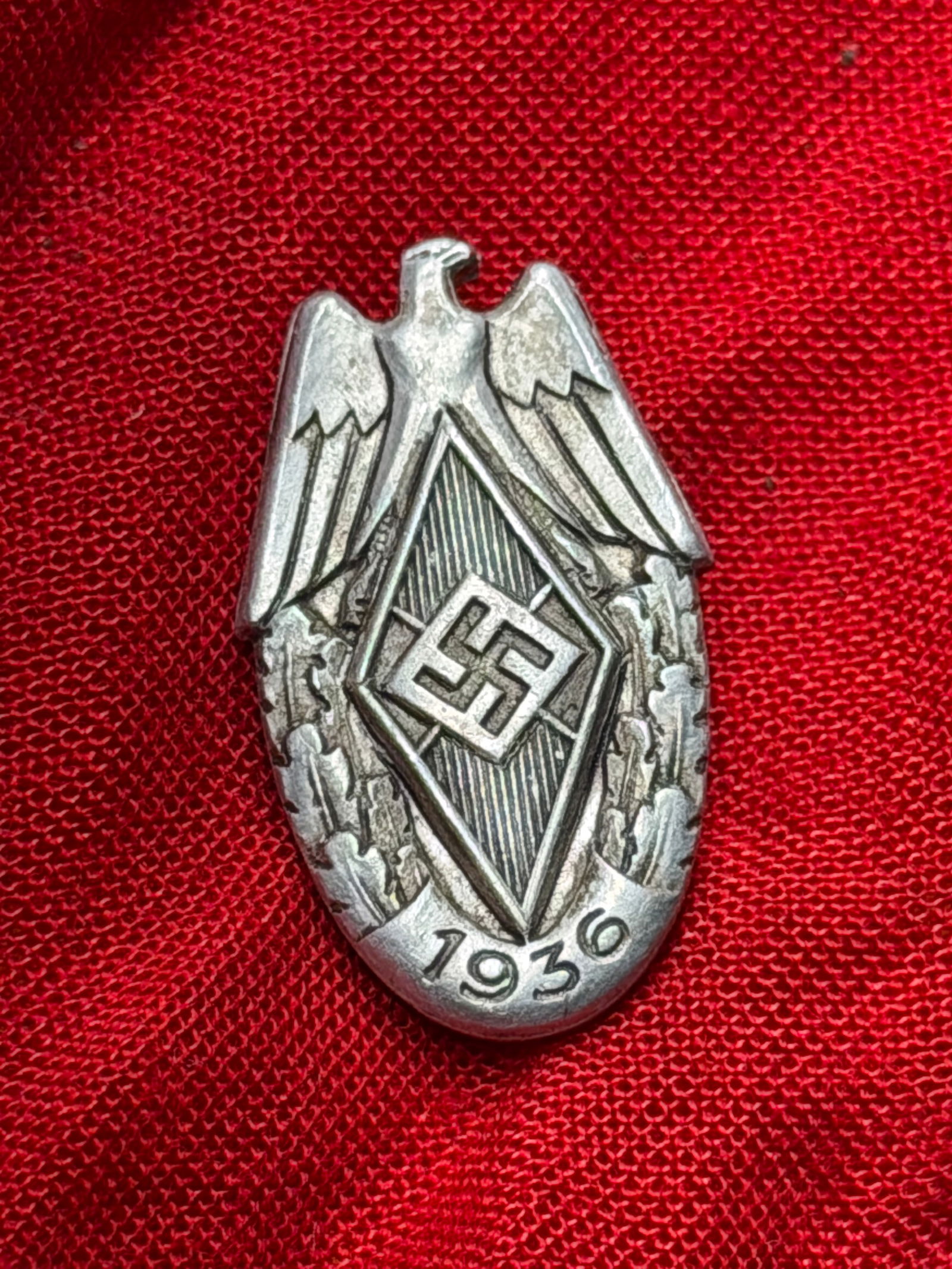WW2 German Hitler Youth Membership Badge (Hitlerjugend Abzeichen), c. 1930s: This metal badge is an original Hitler Youth (Hitlerjugend) membership badge, issued in Nazi Germany during the 1930s. The obverse features the Hitler Youth emblem: a diamond-shaped field bearing the