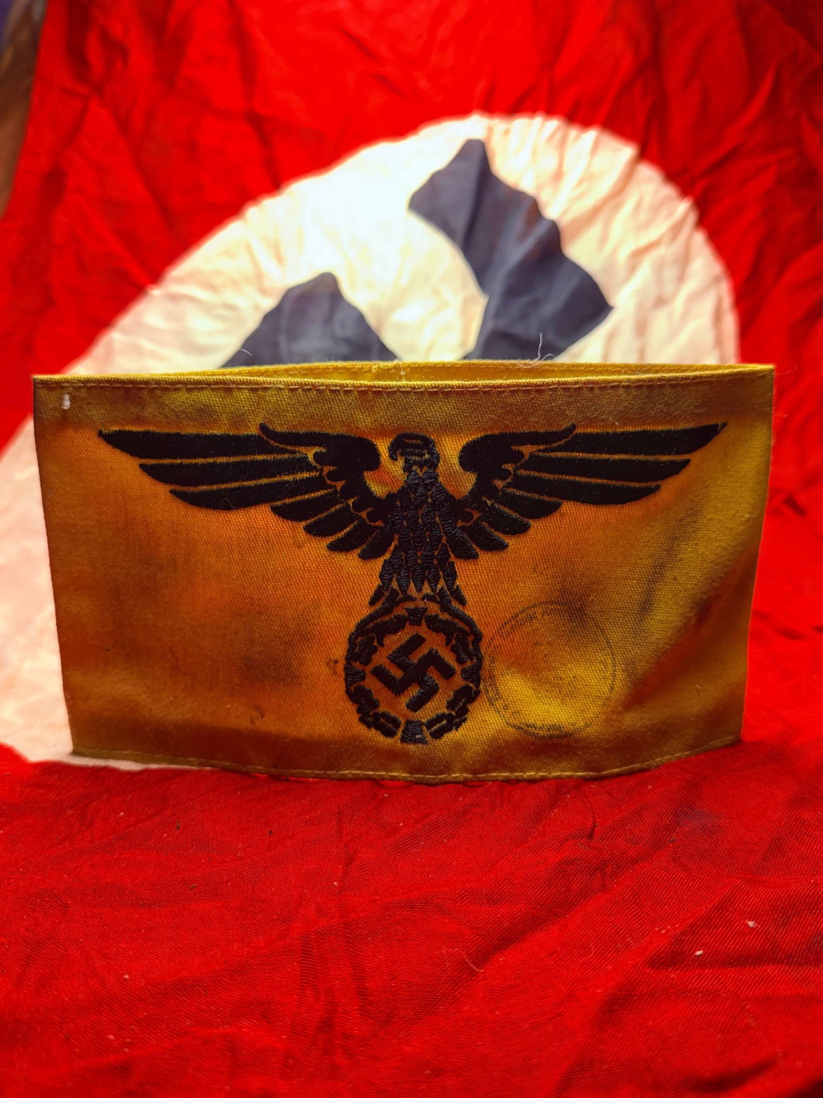 WW2 German State Service Armband: This yellow armband bears the black National Socialist state eagle clutching a wreath enclosing a swastika, a symbol used by various German civil and state service organizations during the Third Reich