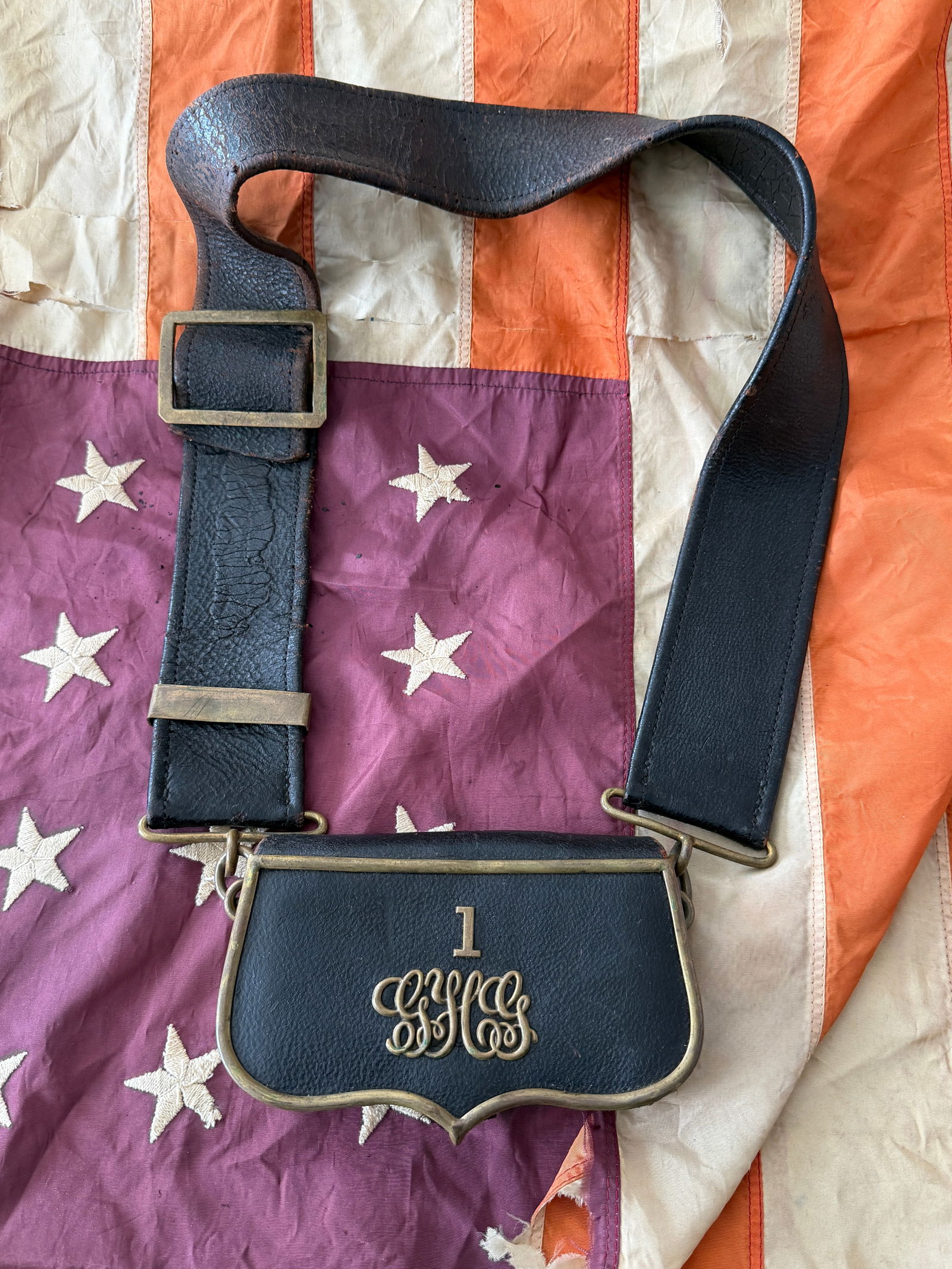 U.S. Civil War Leather Cartridge Box with Shoulder Sling, Marked “1 GHS: This original mid-19th-century leather cartridge box and shoulder sling dates to the American Civil War era (1861–1865). Constructed of blackened leather with brass fittings, the box features a scal