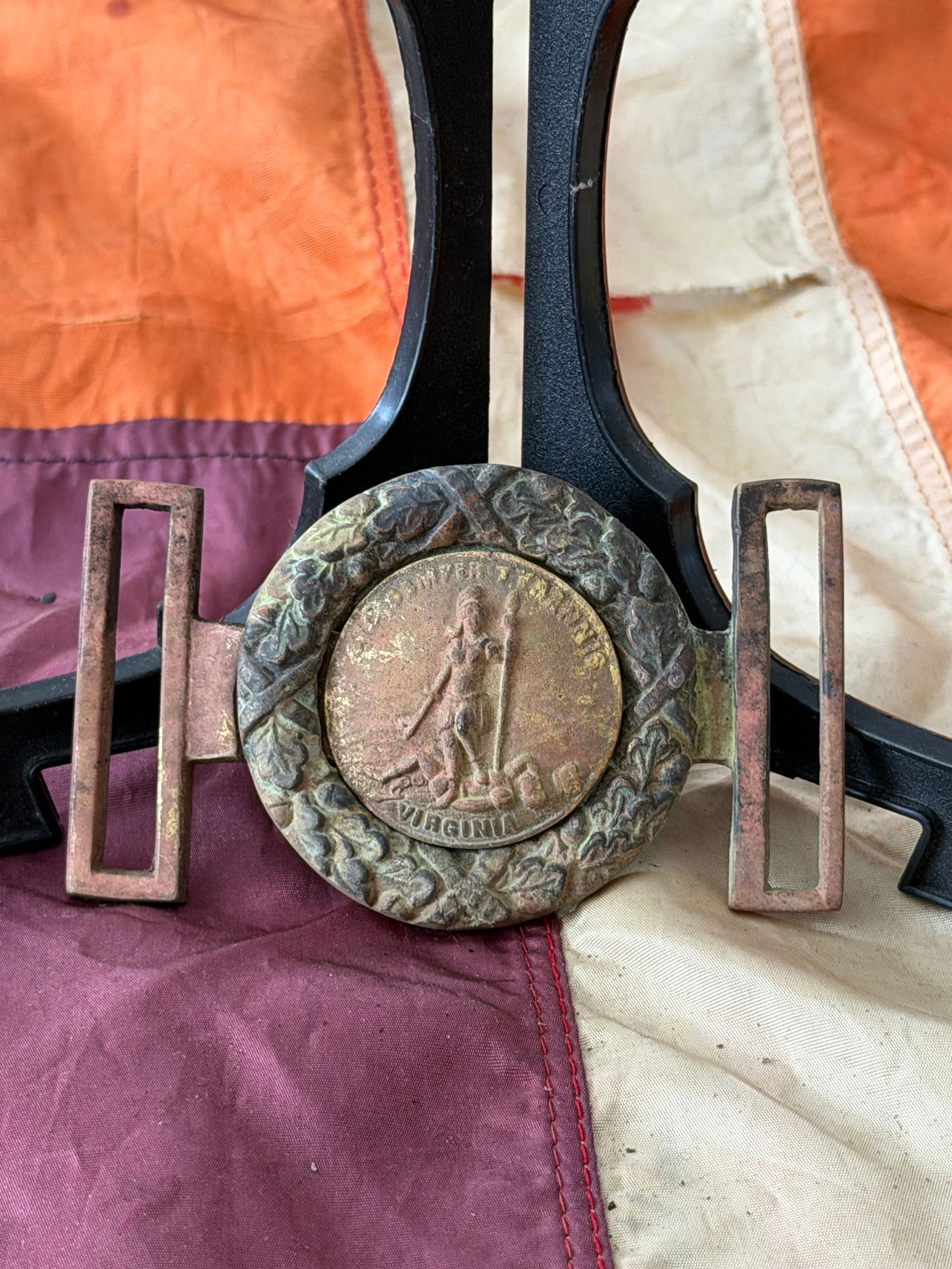 Virginia State Seal Belt Plate (Confederate), American Civil War: This oval belt plate features the Great Seal of the Commonwealth of Virginia, depicting the classical figure Virtus standing over a fallen tyrant, accompanied by the motto “Sic Semper Tyrannis&rdquo