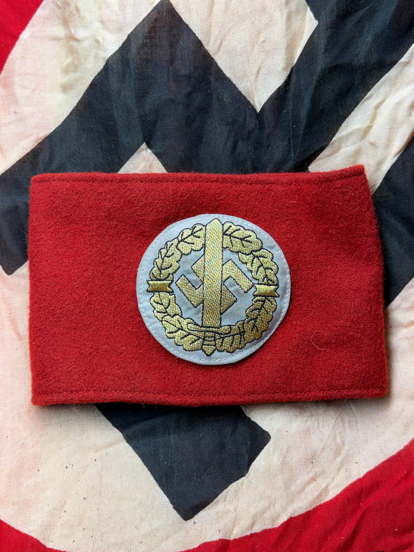 WW2 German SA Armband with Rank Insignia and RZM Tag, Germany, c. 1934–1945: This red wool armband is an original example of insignia worn by members of the Sturmabteilung (SA), the Nazi Party’s paramilitary organization. The armband features a machine-woven roundel bearing