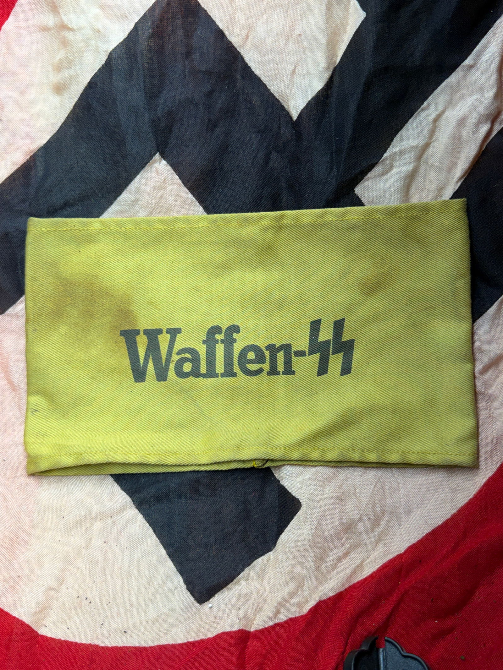 WW2 German Waffen-SS Identification Armband with RZM Tag, Germany, c. 1939–1945: This yellow cloth armband is an original identification item associated with the Waffen-SS, the armed branch of the Schutzstaffel during the Second World War. The armband is machine-printed with the t