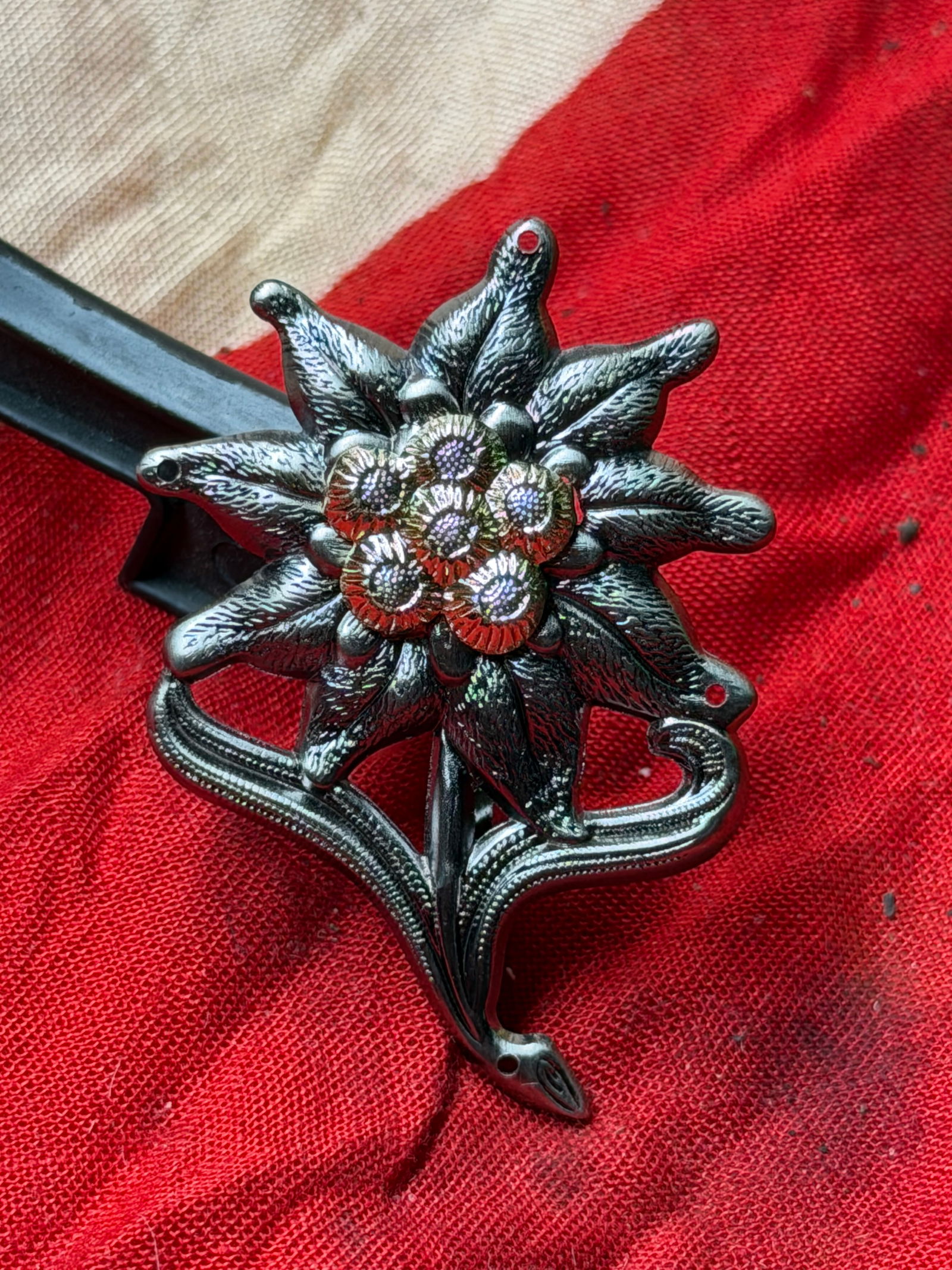 WW2 German Edelweiß Insignia (Mountain Troops Emblem), Germany: This metal Edelweiß (edelweiss flower) insignia is associated with German mountain troops, traditionally known as Gebirgsjäger. The edelweiss flower—native to the high Alpine regions of Europe—w