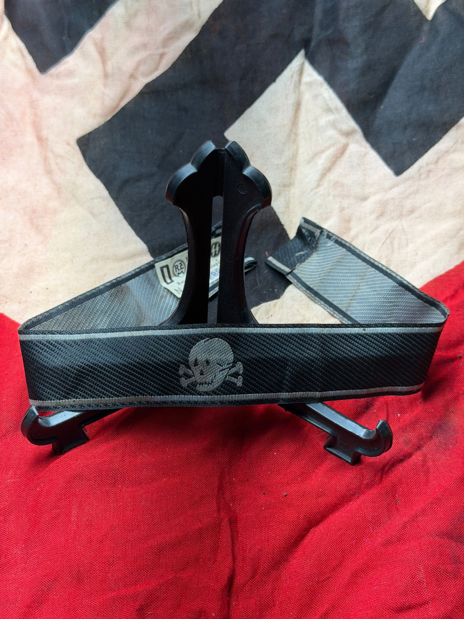 WW2 German SS Totenkopf Cuff Title (Sleeve Band), Waffen-SS With RZM Paper Tag: This black woven cuff title bears the Totenkopf (skull-and-crossbones) emblem associated with the Waffen-SS, most notably units linked to the Totenkopf tradition. Worn on the lower sleeve of the unifo